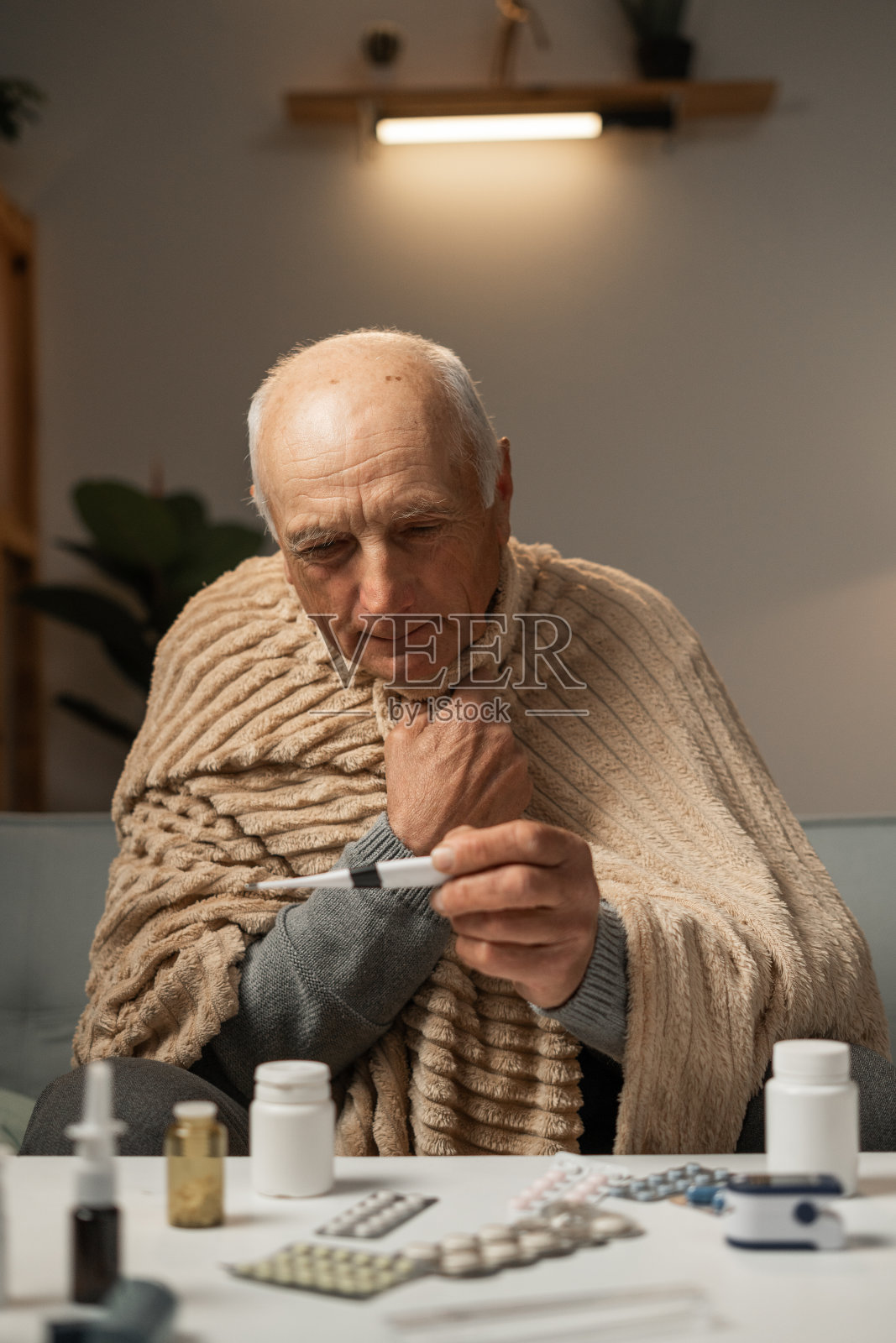 人用温度计测体温。他有病毒性流感的症状服用药片照片摄影图片