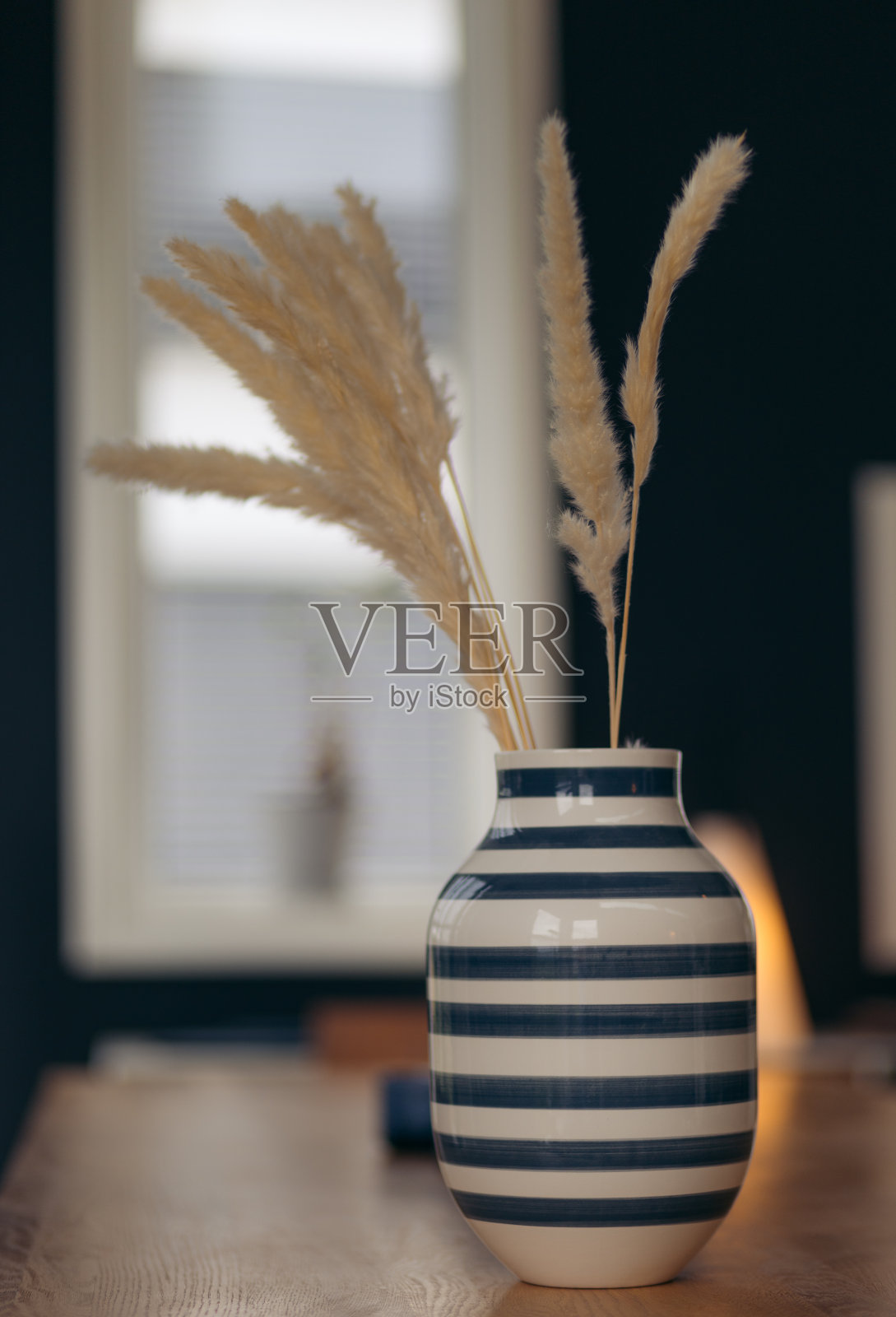 一个装有吸管的蓝白相间的条纹花瓶特写照片摄影图片