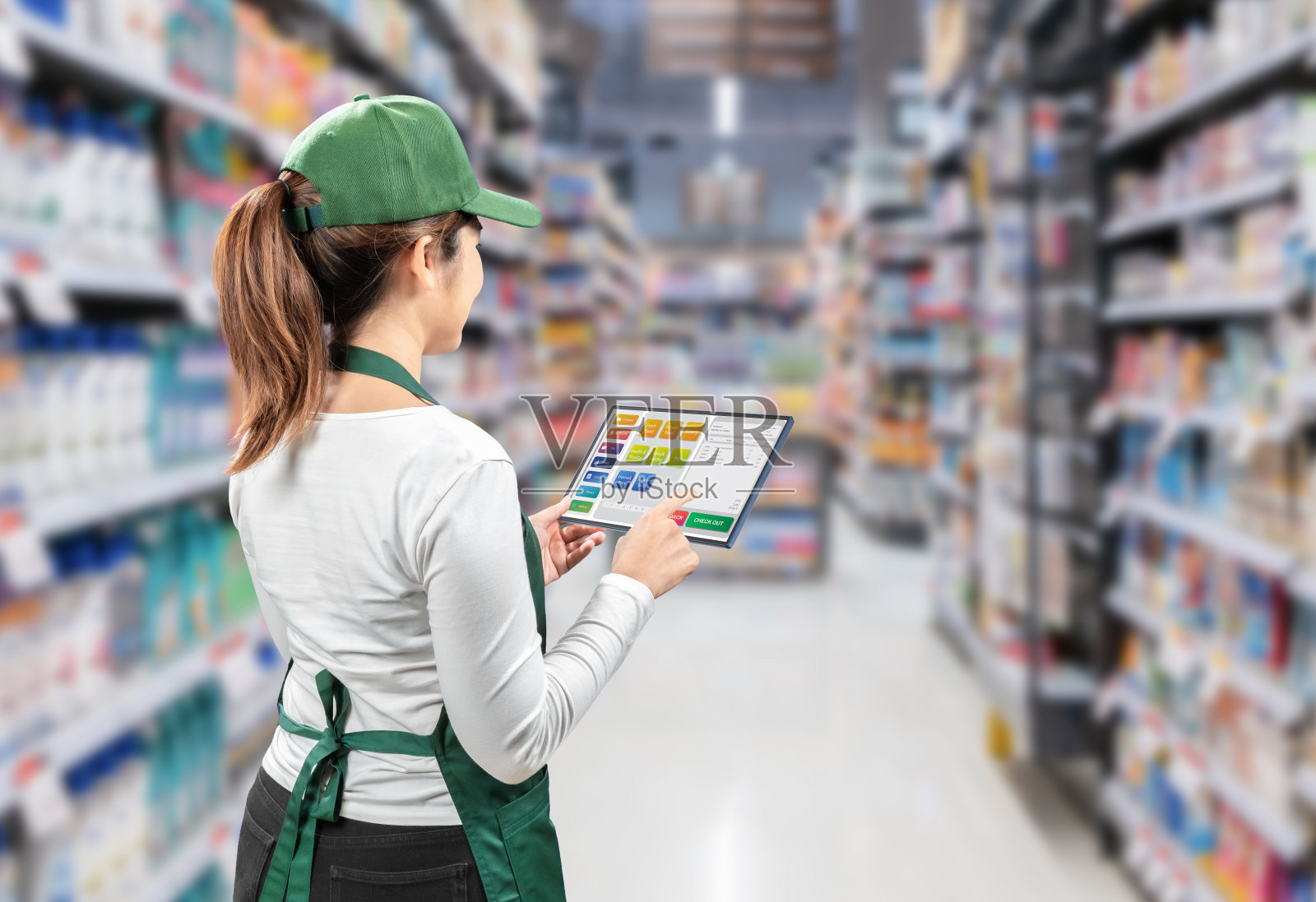 亚洲卖家穿着绿色围裙和帽子在零售商店后视图照片摄影图片