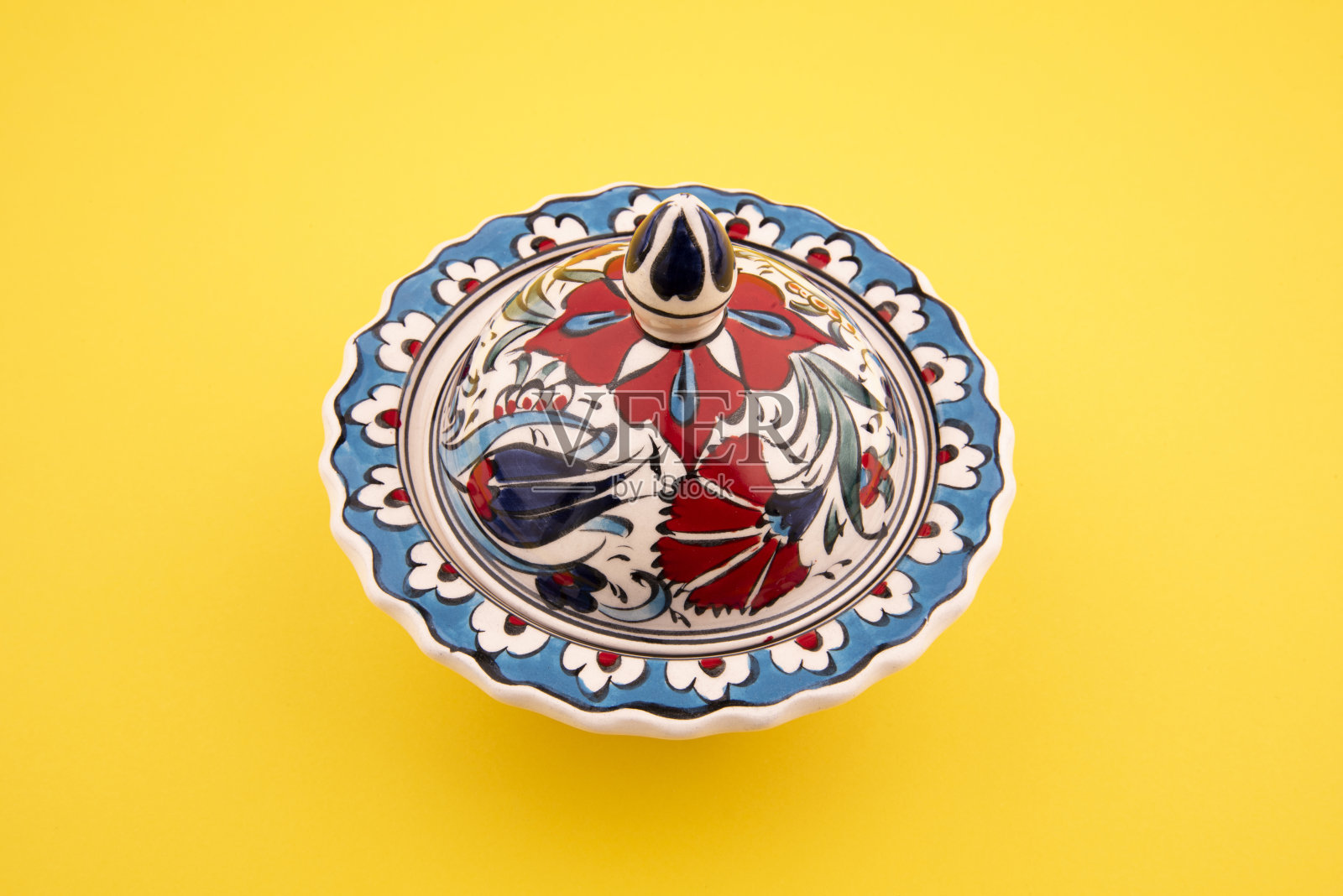 带盖的郁金香图案碗。碗盖在黄色背景照片摄影图片