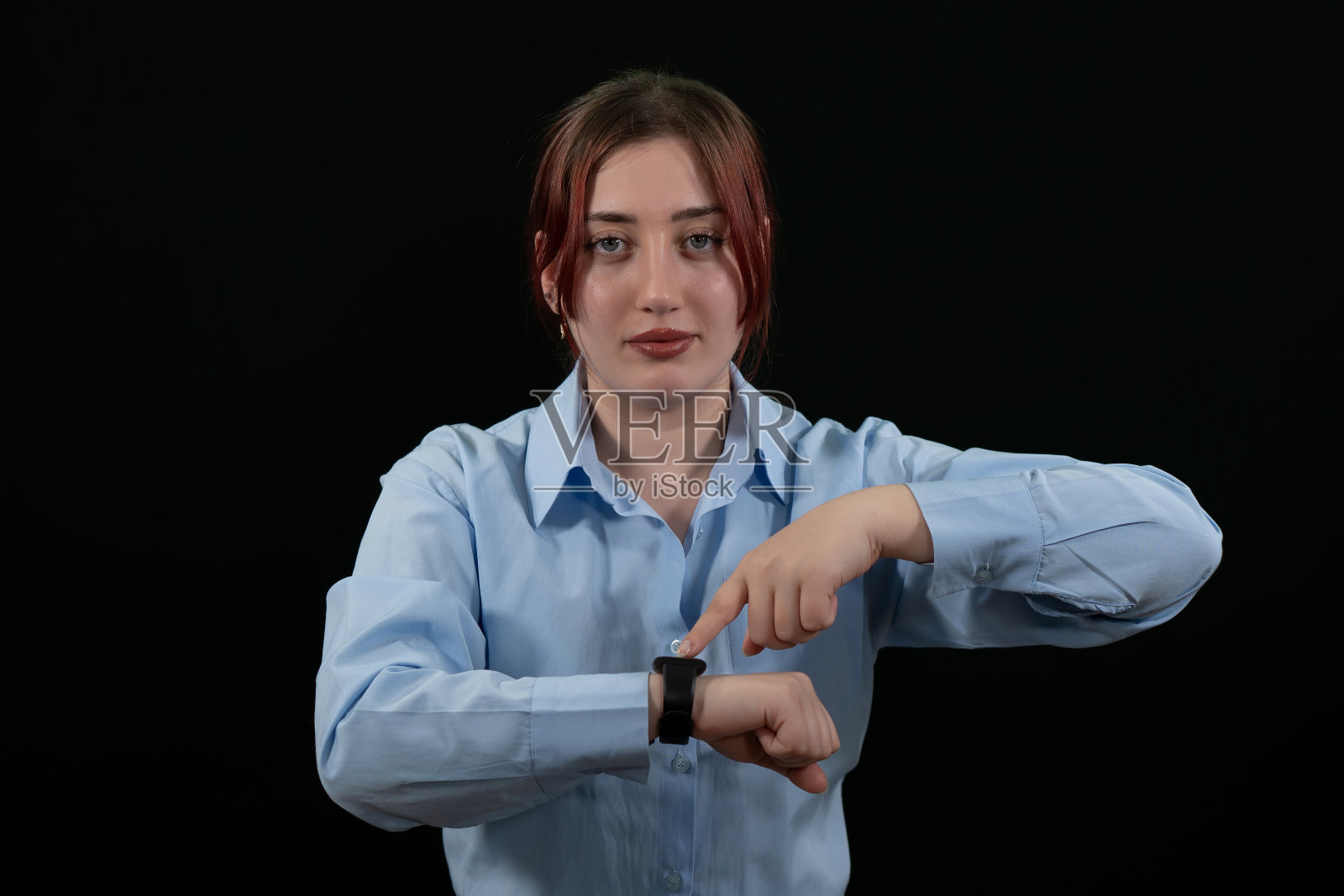 商务人士在办公室工作时使用智能手表。商人使用智能手表的手特写。黑色背景。照片摄影图片