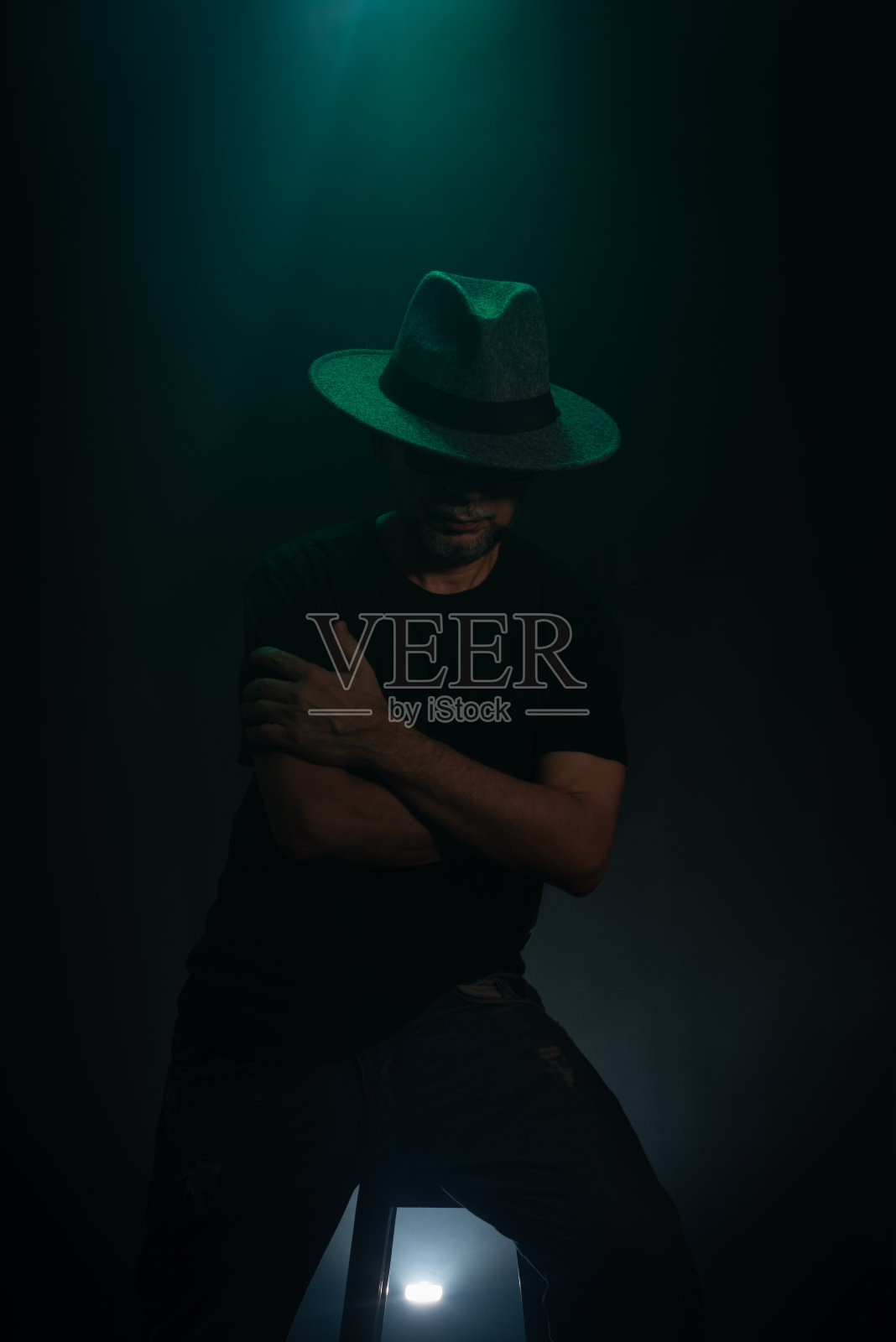 戴着帽子、留着胡子的神秘男子在镜头前摆姿势。工作室肖像。照片摄影图片