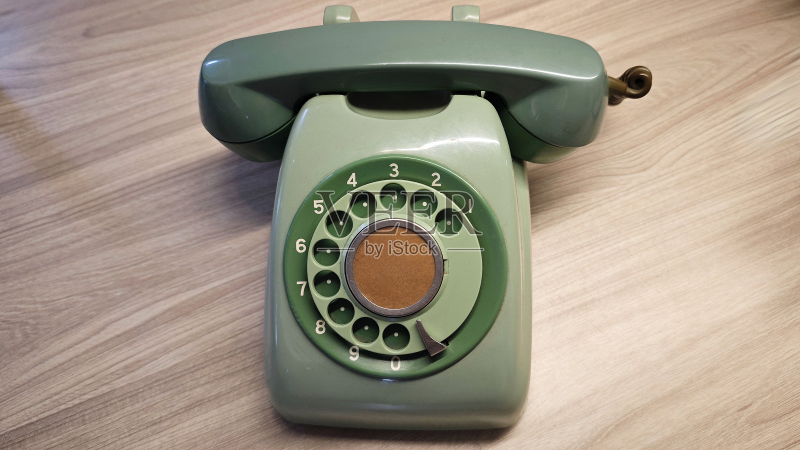 复古绿色旋转拨号电话或电话在木制表面在经典设计照片摄影图片