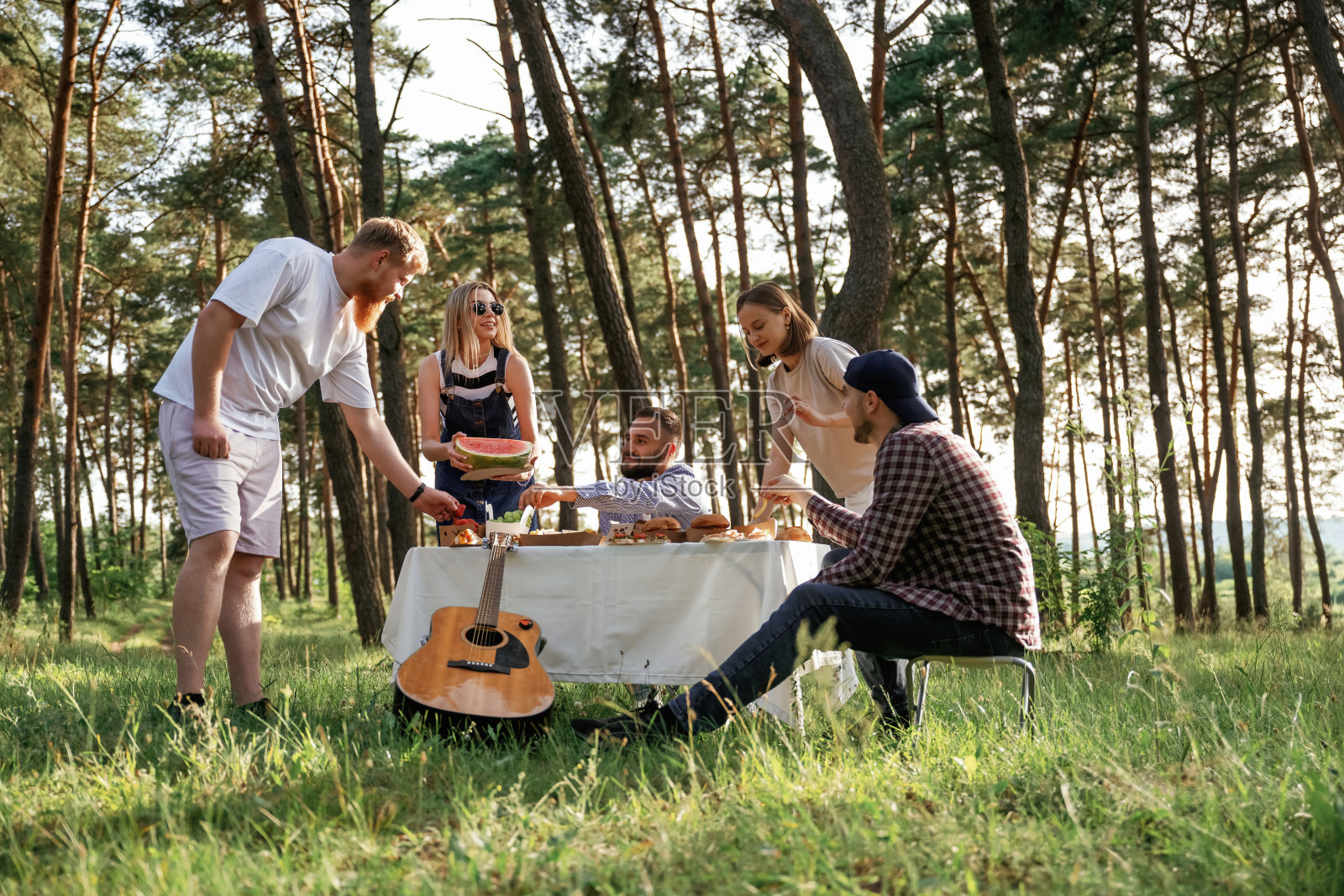 饭菜在桌子上。一群朋友在野外野餐,食物放在生态盒里照片摄影图片