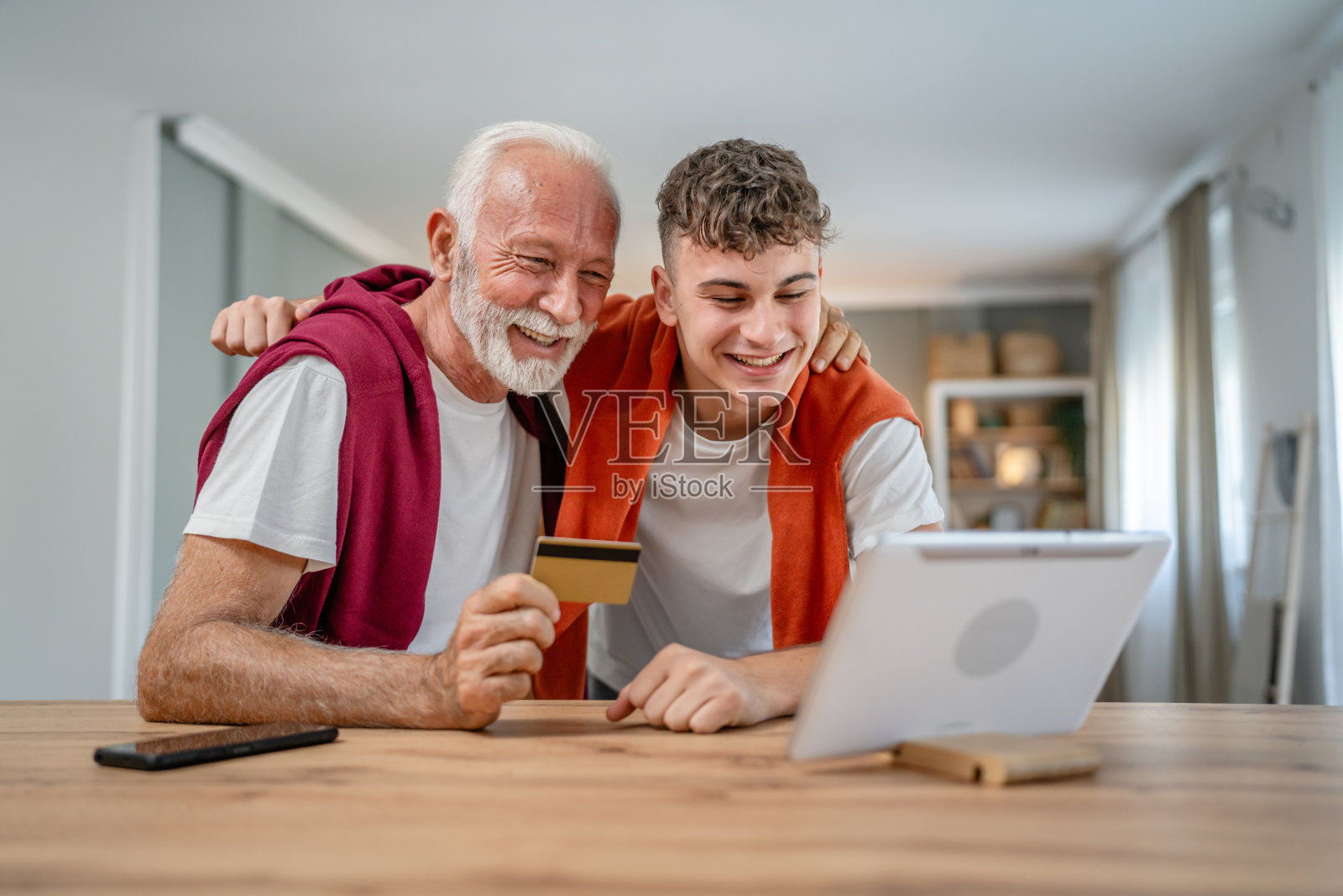青少年和老年男子爷爷使用信用卡网上购物照片摄影图片