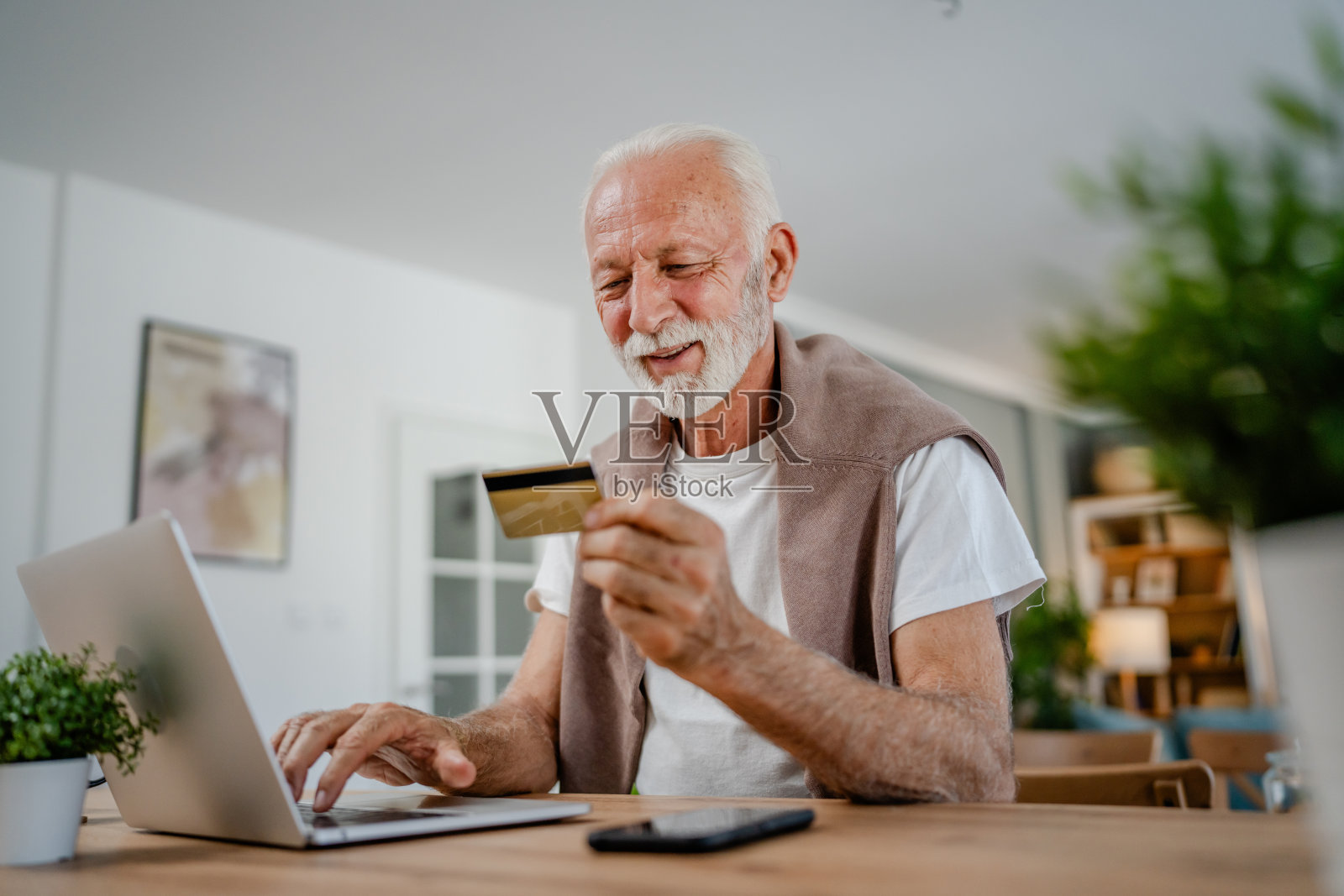 一位老人用笔记本电脑持有信用卡,在网上购物照片摄影图片