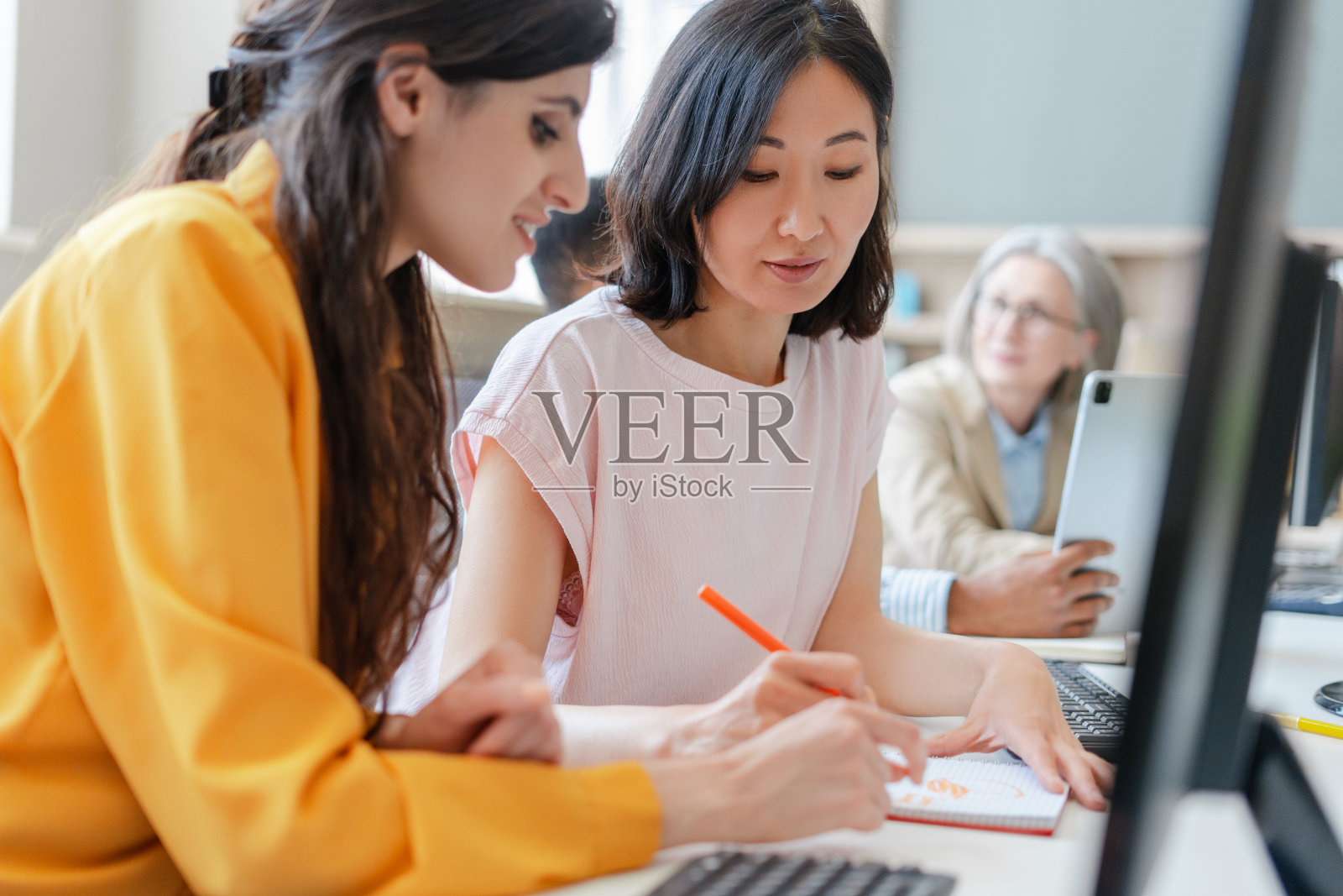 两个女人在繁忙的办公室里合作一个项目照片摄影图片