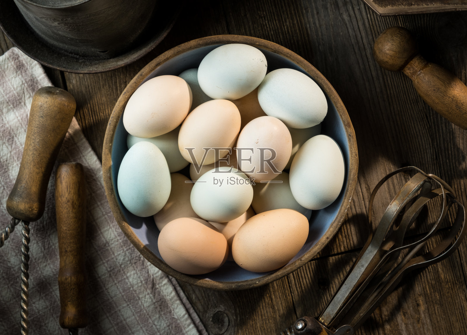 一碗五颜六色的新鲜鸡蛋放在木桌上照片摄影图片