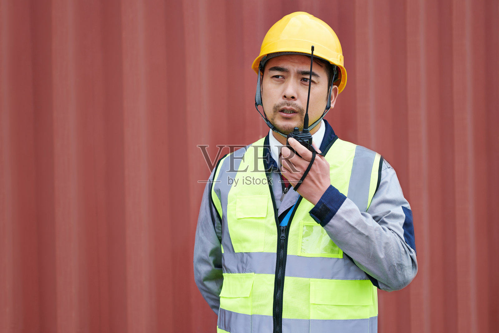 红色集装箱的一名亚洲工人照片摄影图片
