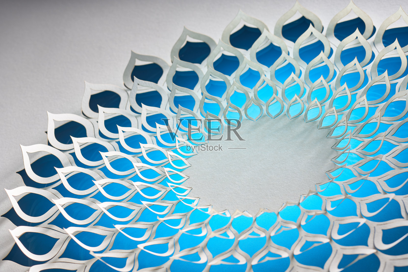 复杂的几何纸艺术装置,以蓝色色调渐变的花卉设计为特色,创造出令人着迷的视觉效果。照片摄影图片