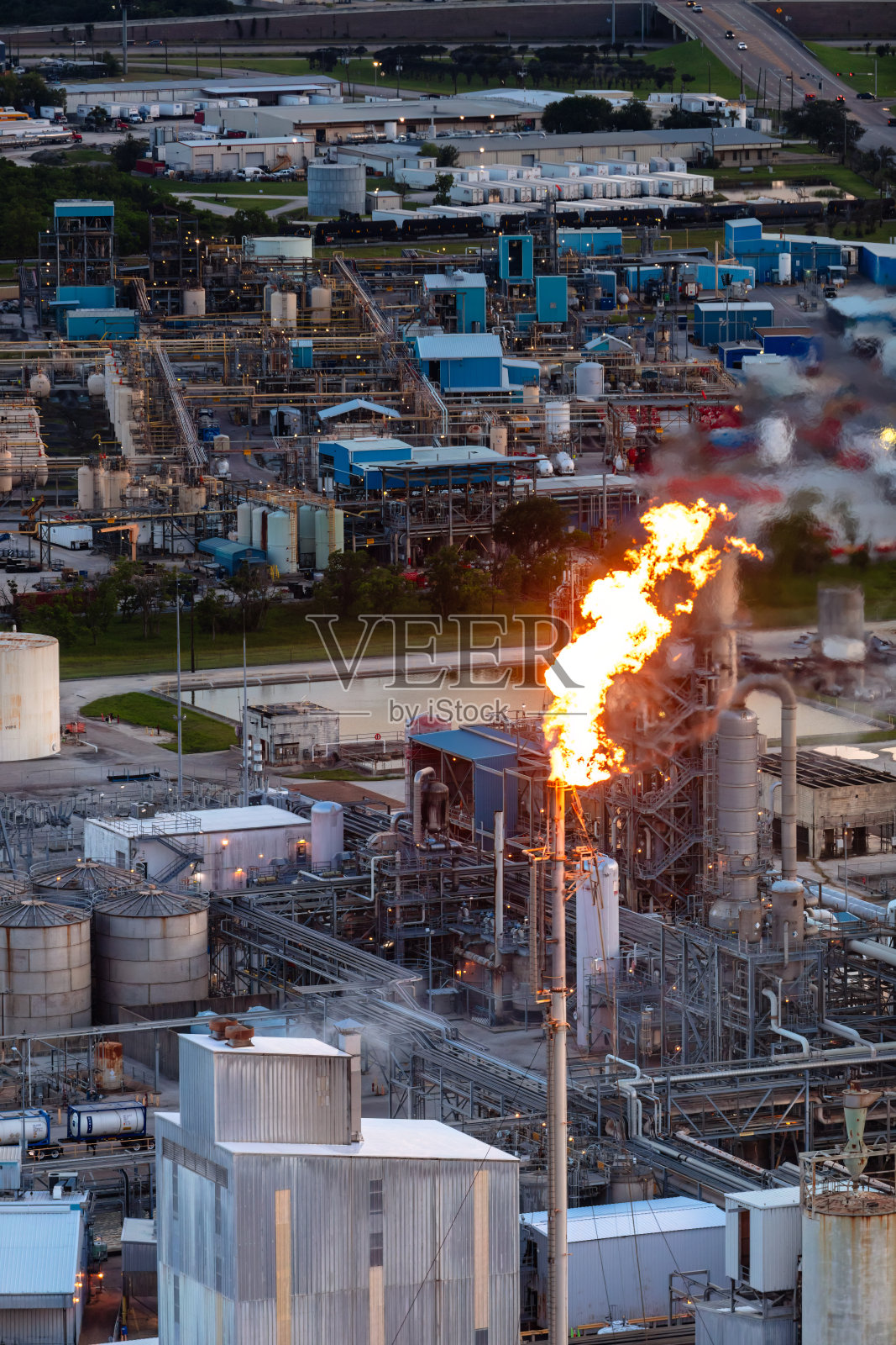 燃烧的烟囱在炼油厂在休斯敦,得克萨斯州在晚上-直升机拍摄照片摄影图片