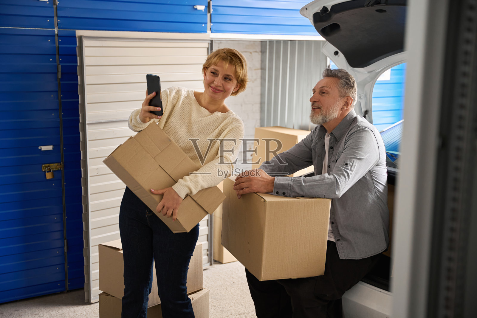 一男一女站在汽车旁边的自助储藏室里照片摄影图片