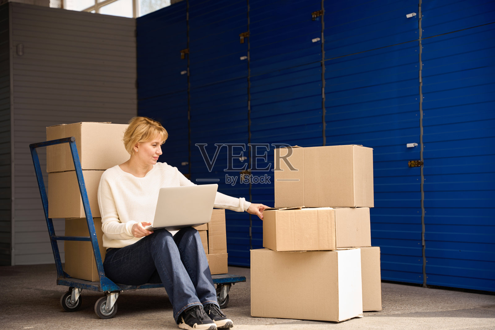 一位女士坐在仓库里摆弄电脑照片摄影图片