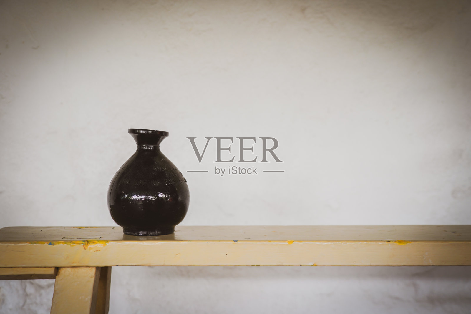 木凳上的黑色花瓶,带有戏剧性的色调照片摄影图片