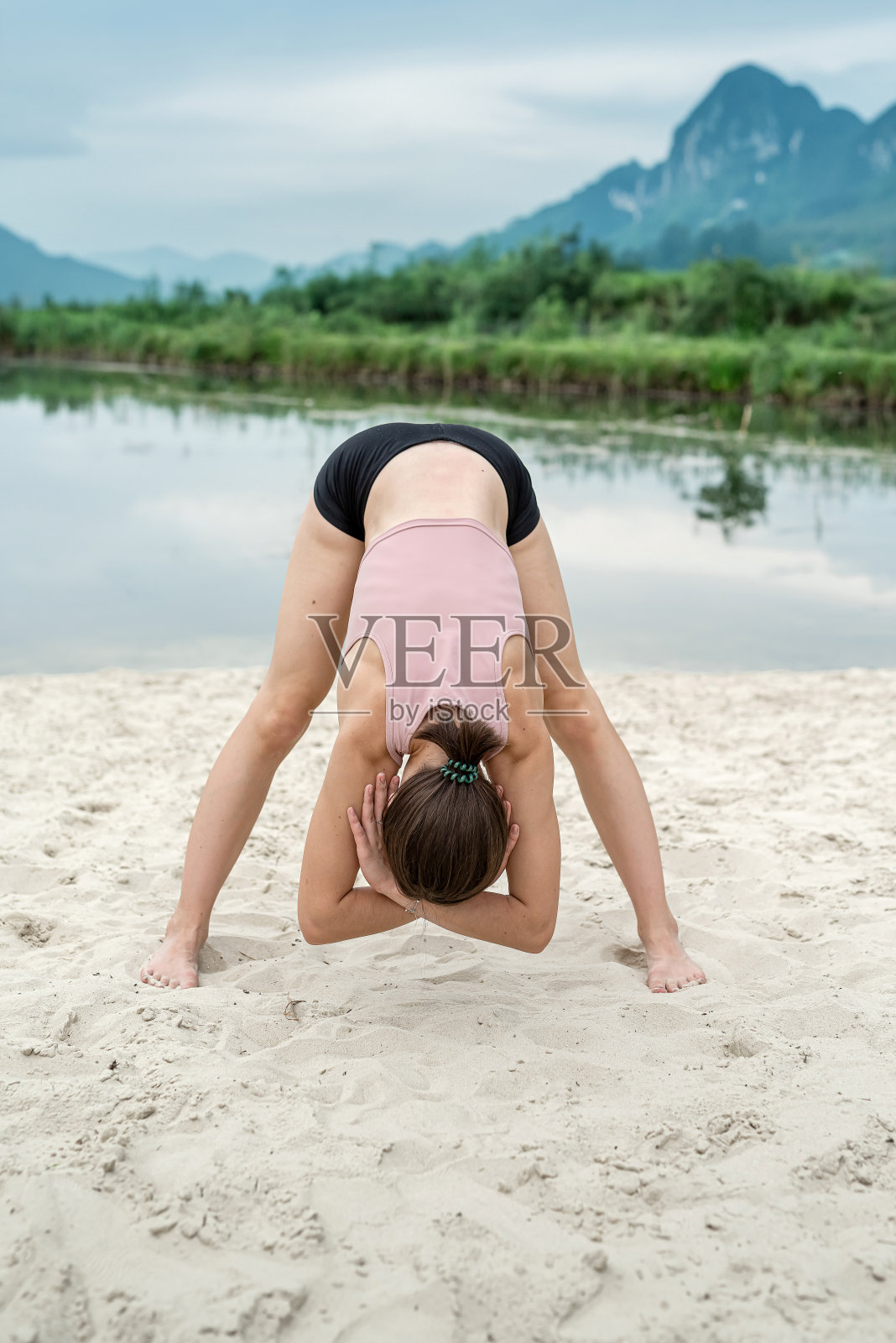 年轻的白人妇女在湖边和山上做瑜伽或普拉提健康运动照片摄影图片