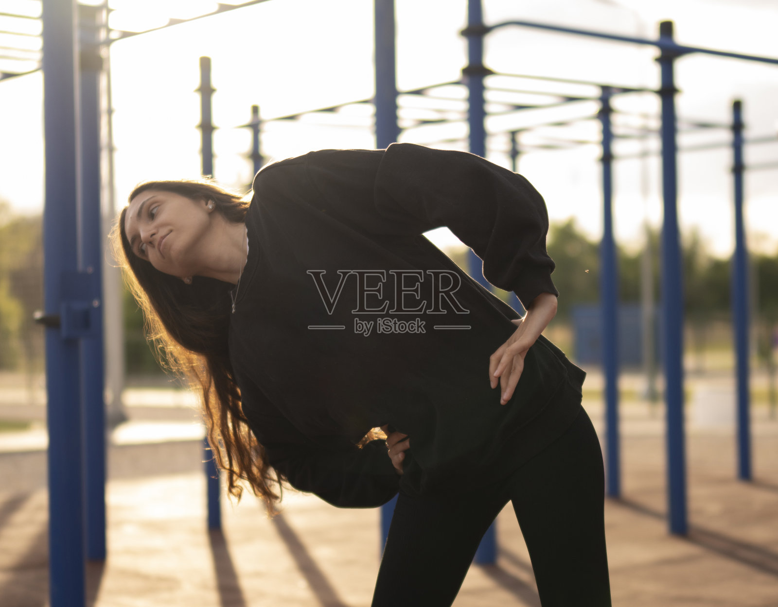 在早晨阳光下做日常运动的妇女在户外伸展照片摄影图片