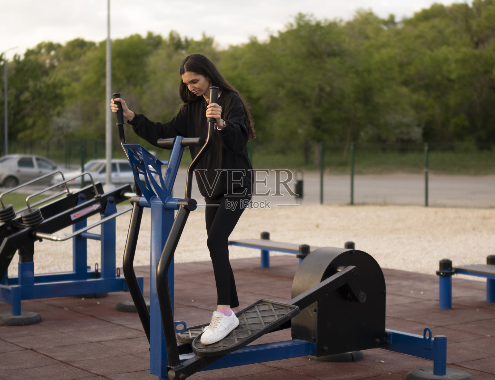 女运动员在室外椭圆机上进行腿部训练照片摄影图片