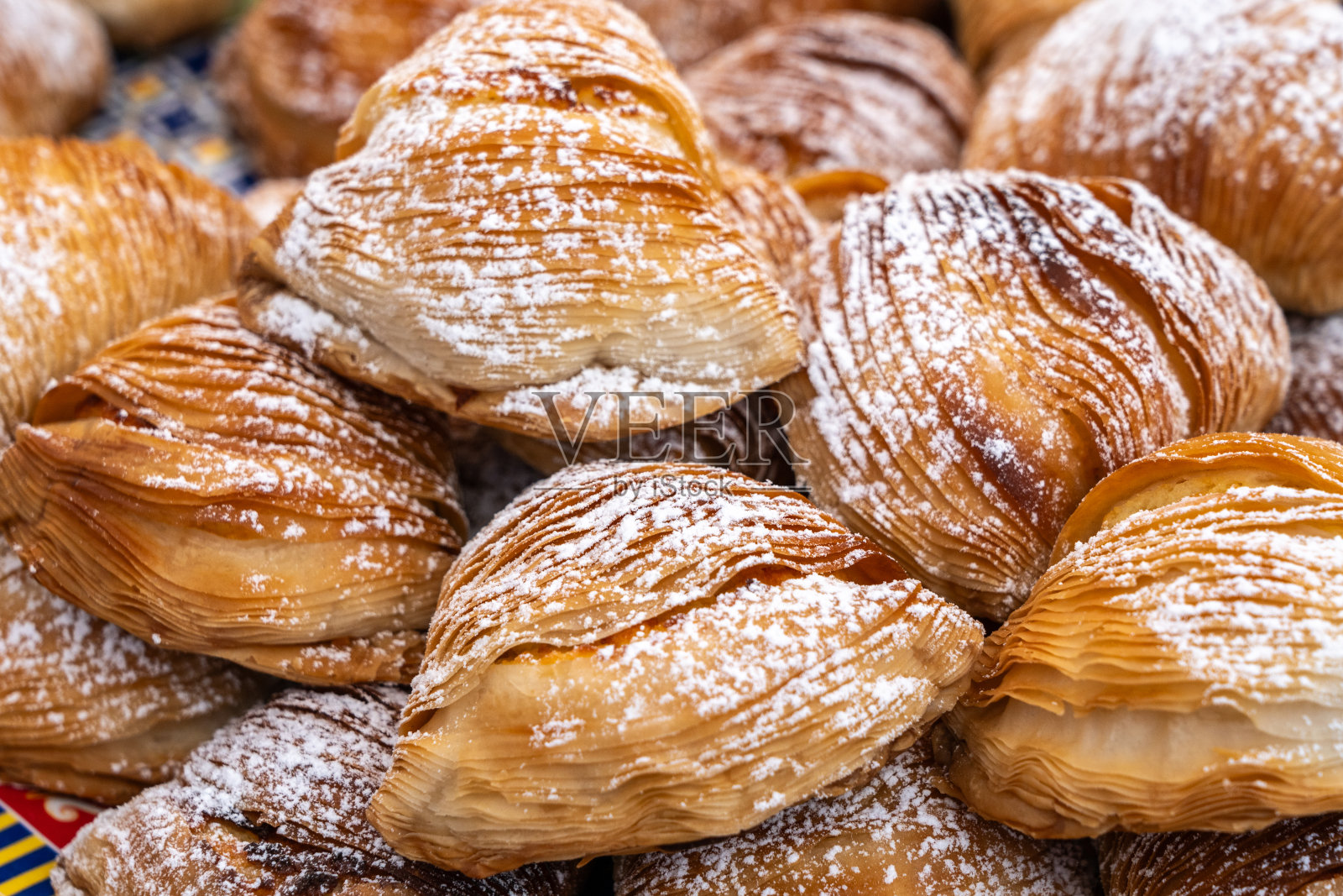 Sfogliatella糕点,一种传统的意大利甜点,上面是薄层的糖粉。新鲜出炉的Sfogliatella照片摄影图片