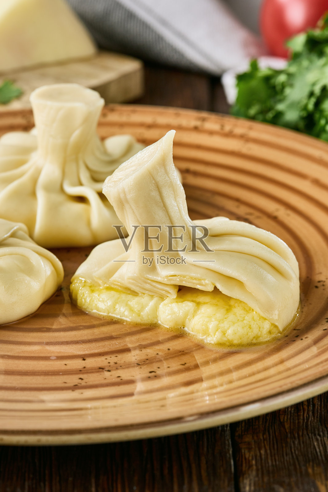 多汁的Khinkali与奶酪在乡村盘子-传统的格鲁吉亚饺子照片摄影图片