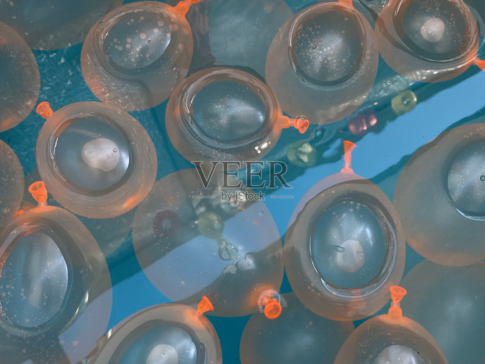 蓝色的浴缸里放着橙色的水球照片摄影图片