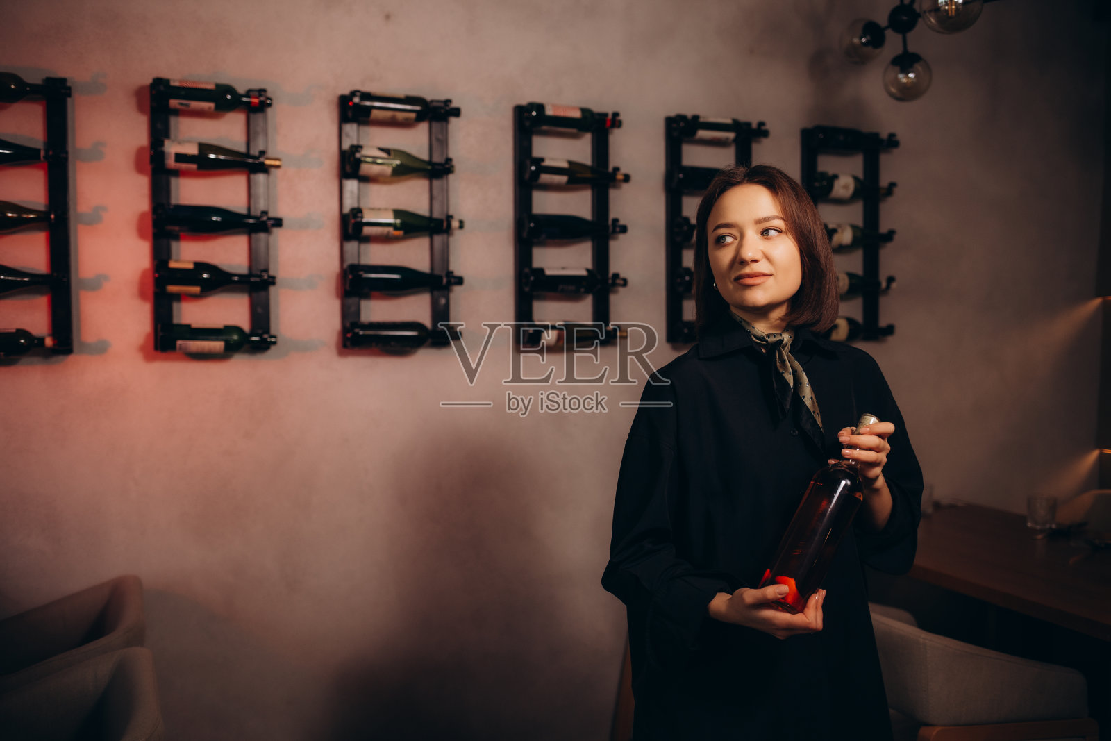 女性侍酒师在阳光照射下的品酒会上举着酒杯的腰部肖像照片摄影图片