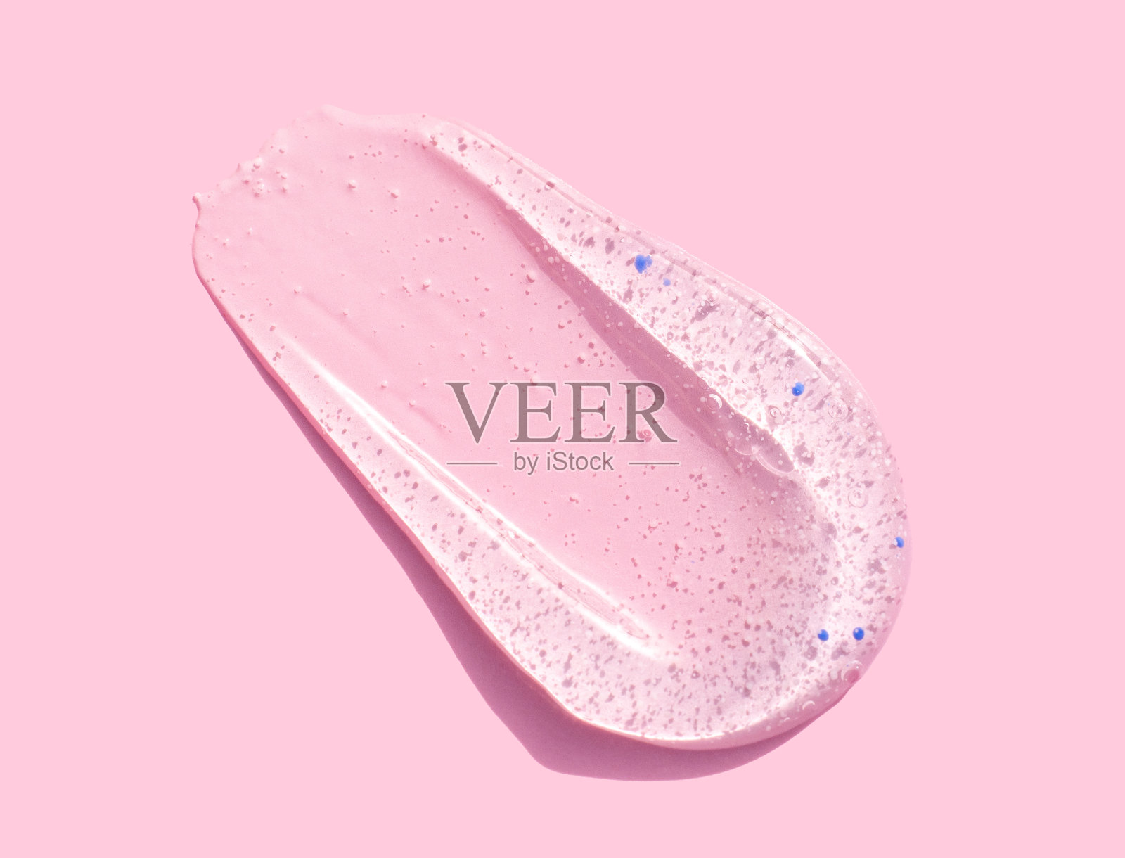 将磨砂化妆品的去皮凝胶测试样品涂抹在粉红色背景上照片摄影图片