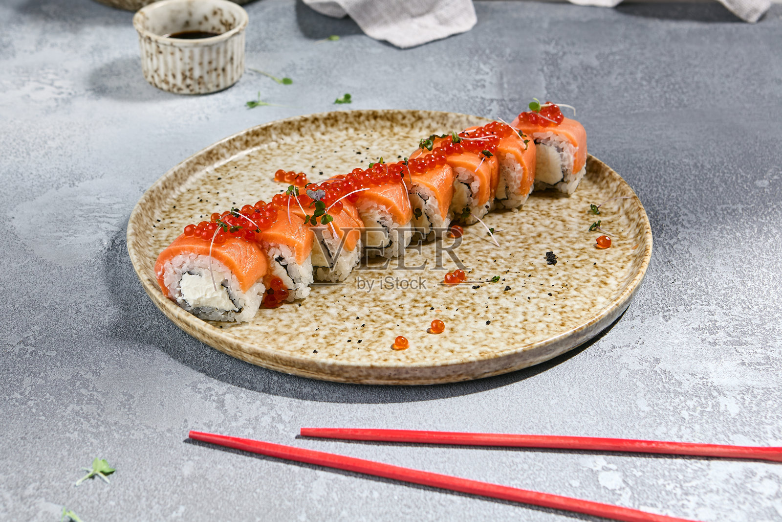 三文鱼卷与红鱼子酱在陶瓷盘-日本寿司特写照片摄影图片