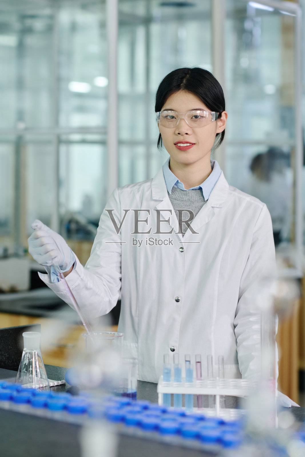 拿着移液管的快乐女科学家照片摄影图片