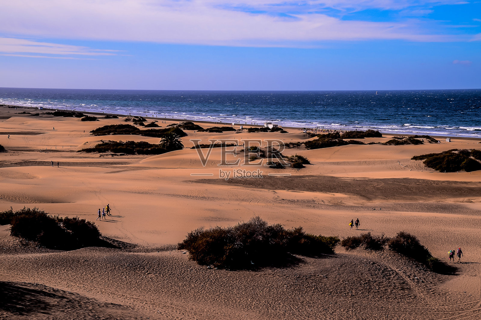 人们在沙滩上散步的海滩场景照片摄影图片