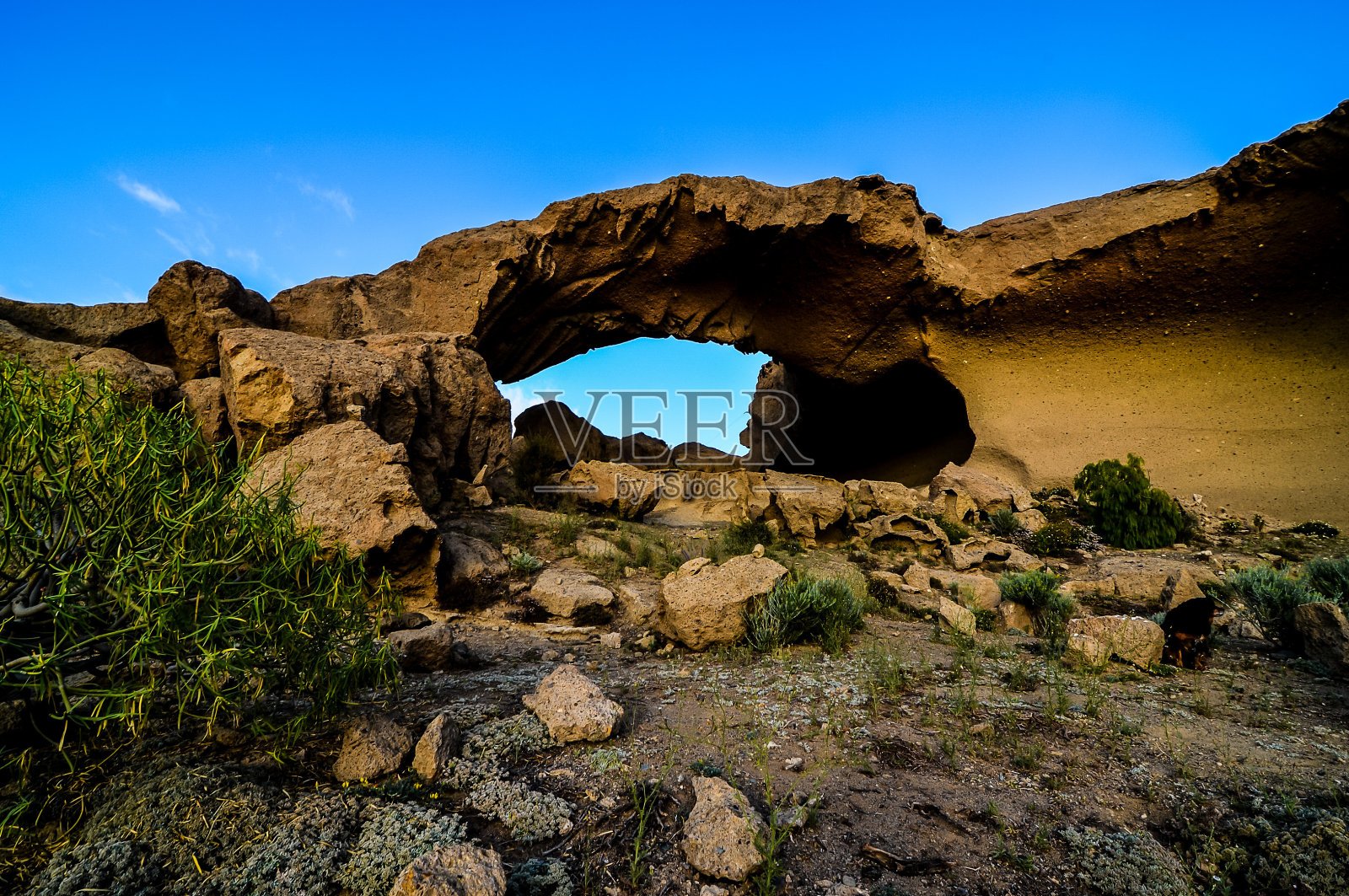 一个巨大的岩石拱门,背景是蓝色的天空照片摄影图片