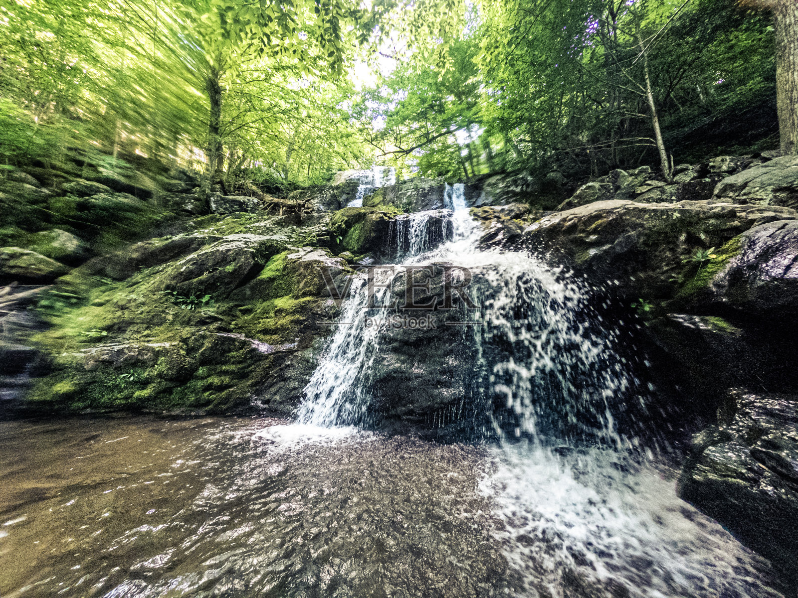 位于自然界的小瀑布的全景视图,水落在岩石上照片摄影图片