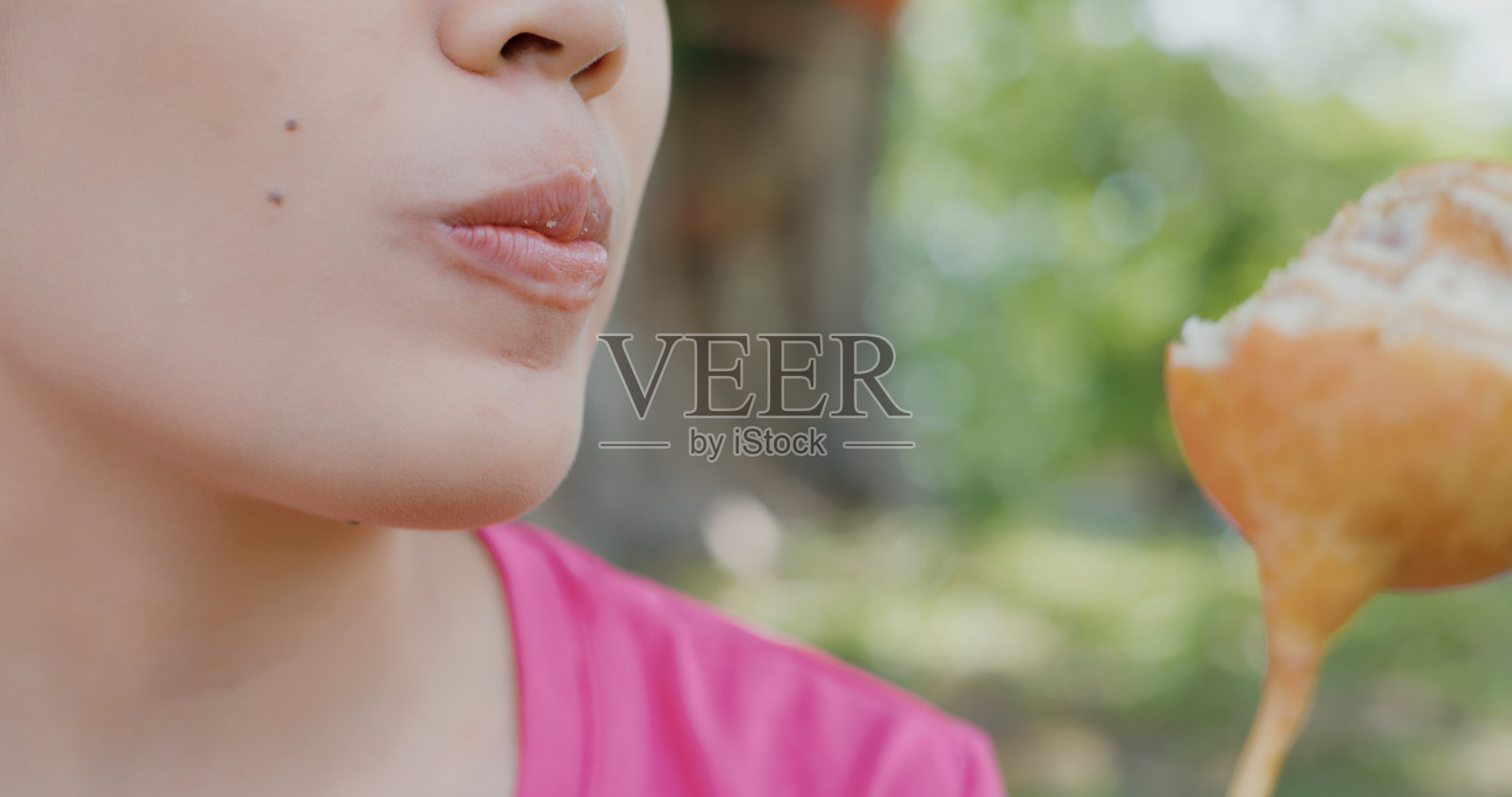 一个年轻女子吃圆面包的特写镜头。照片摄影图片