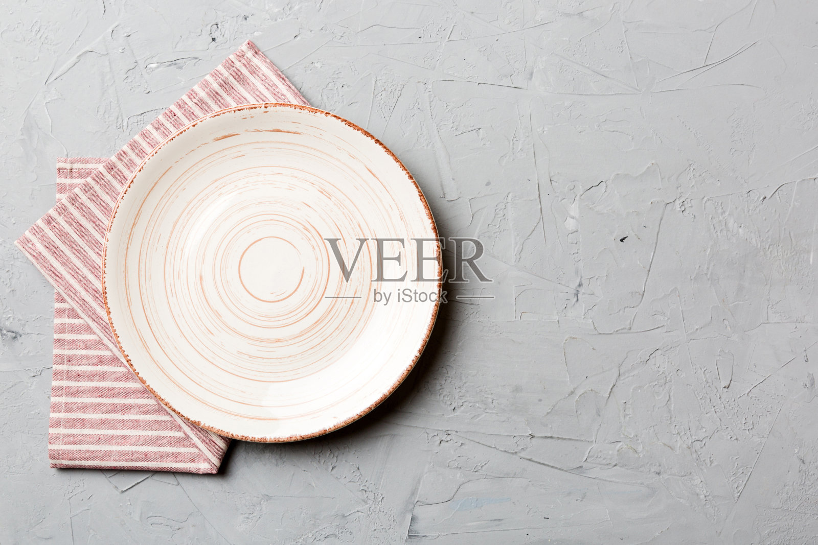 彩色背景上的俯视图,桌布上的空圆形白色盘子盛食物。空盘子放在餐巾上,为你的设计留出空间照片摄影图片