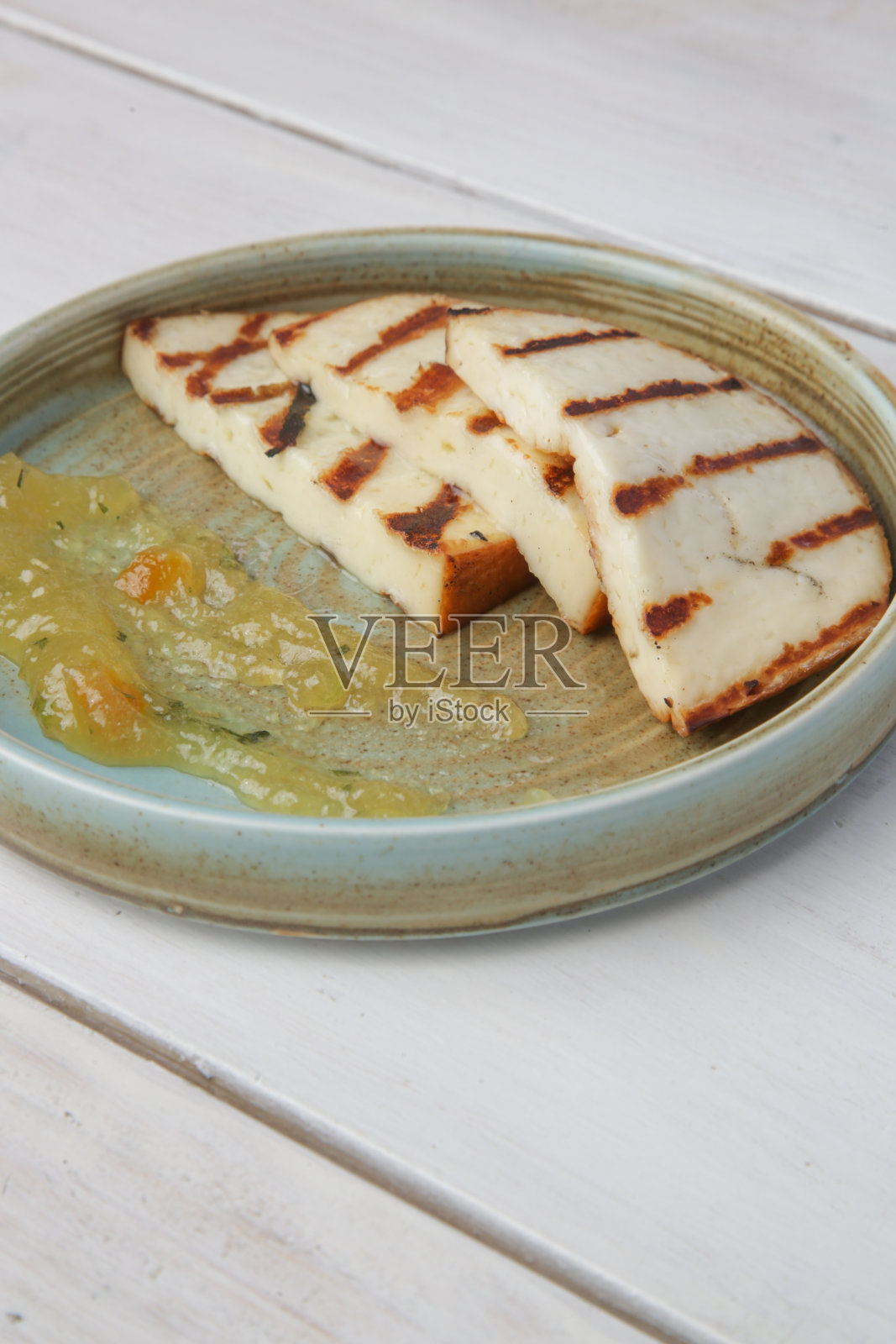 烤塔拉加尼奶酪配香草果酱。照片摄影图片