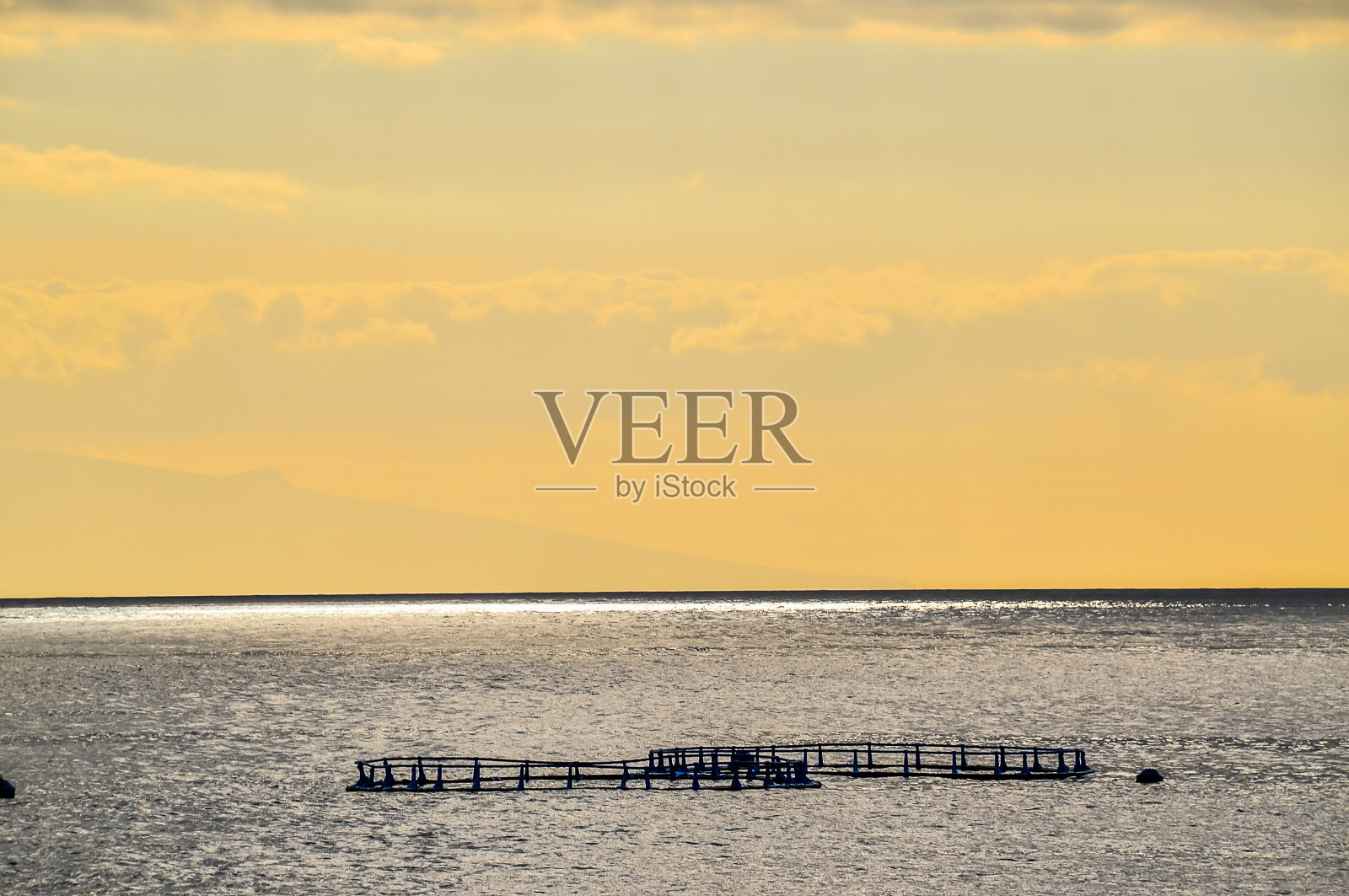 平静的海面上漂着几艘船照片摄影图片