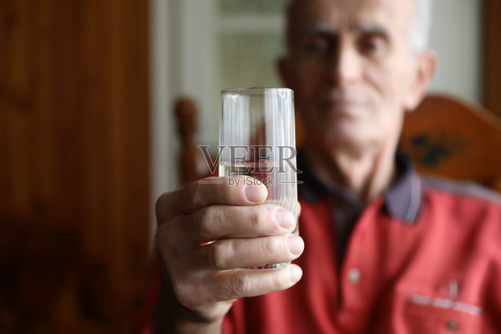 老人手里拿着一杯水,特写照片摄影图片