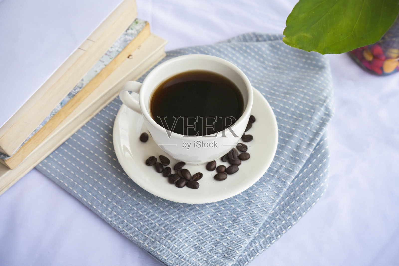 美味的黑咖啡美式浓缩咖啡豆在花式餐厅与书籍和植物照片摄影图片