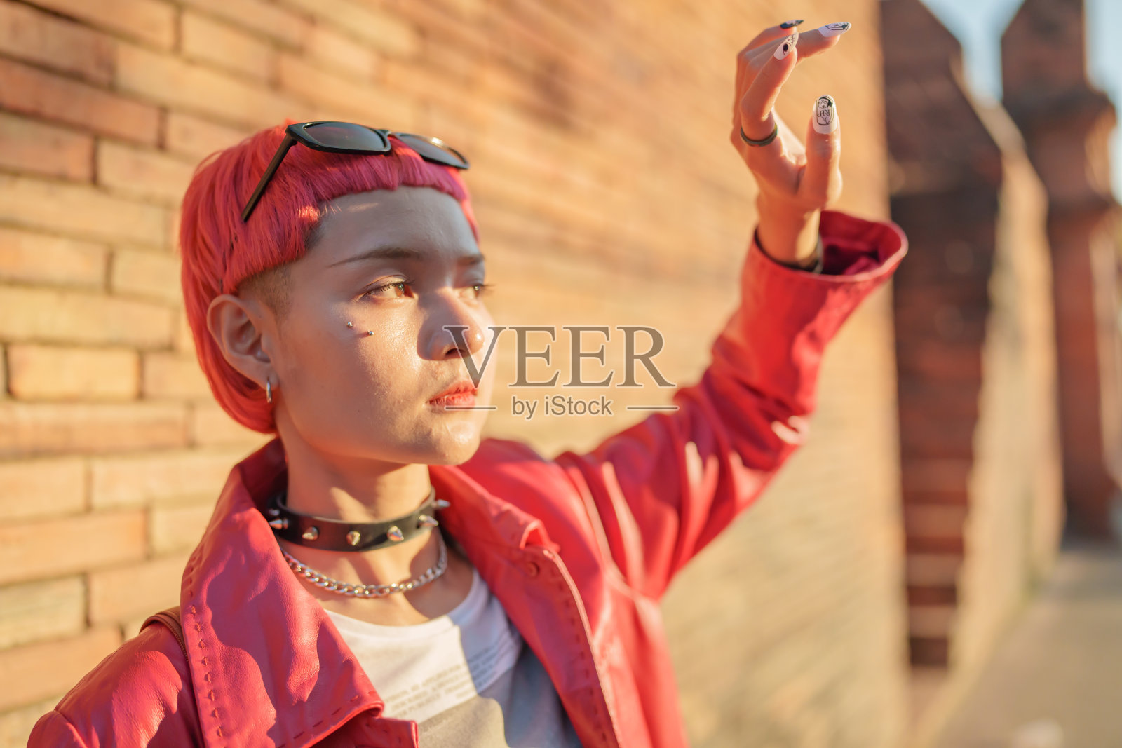 z世代女孩皮革时尚与朋克亚洲妇女旅游当地城市东南亚旅游流行的粉红色发型年轻的女朋克旅行者在城里散步照片摄影图片