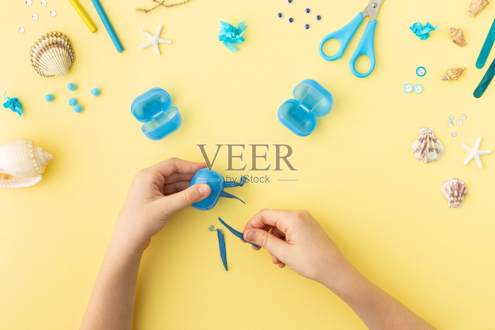 可爱的水母由塑料蓝蛋制成,孩子们可以在家里或幼儿园手工制作。与孩子们一起动手DIY夏季工艺品。海洋的一天。照片摄影图片