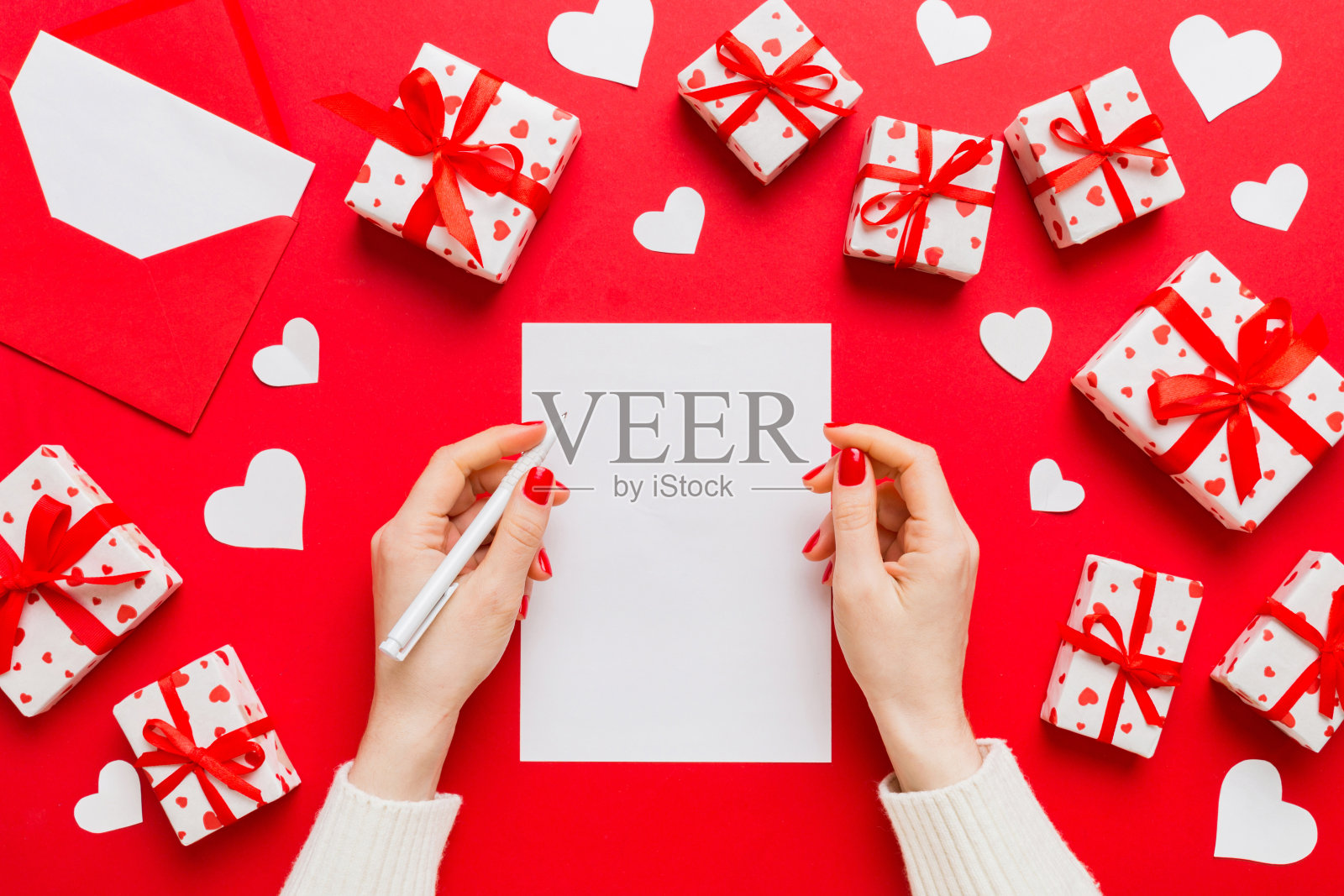 情人节装饰女性手握信与信封,小礼盒和心脏装饰在孤立的彩色背景与空白的空间照片摄影图片