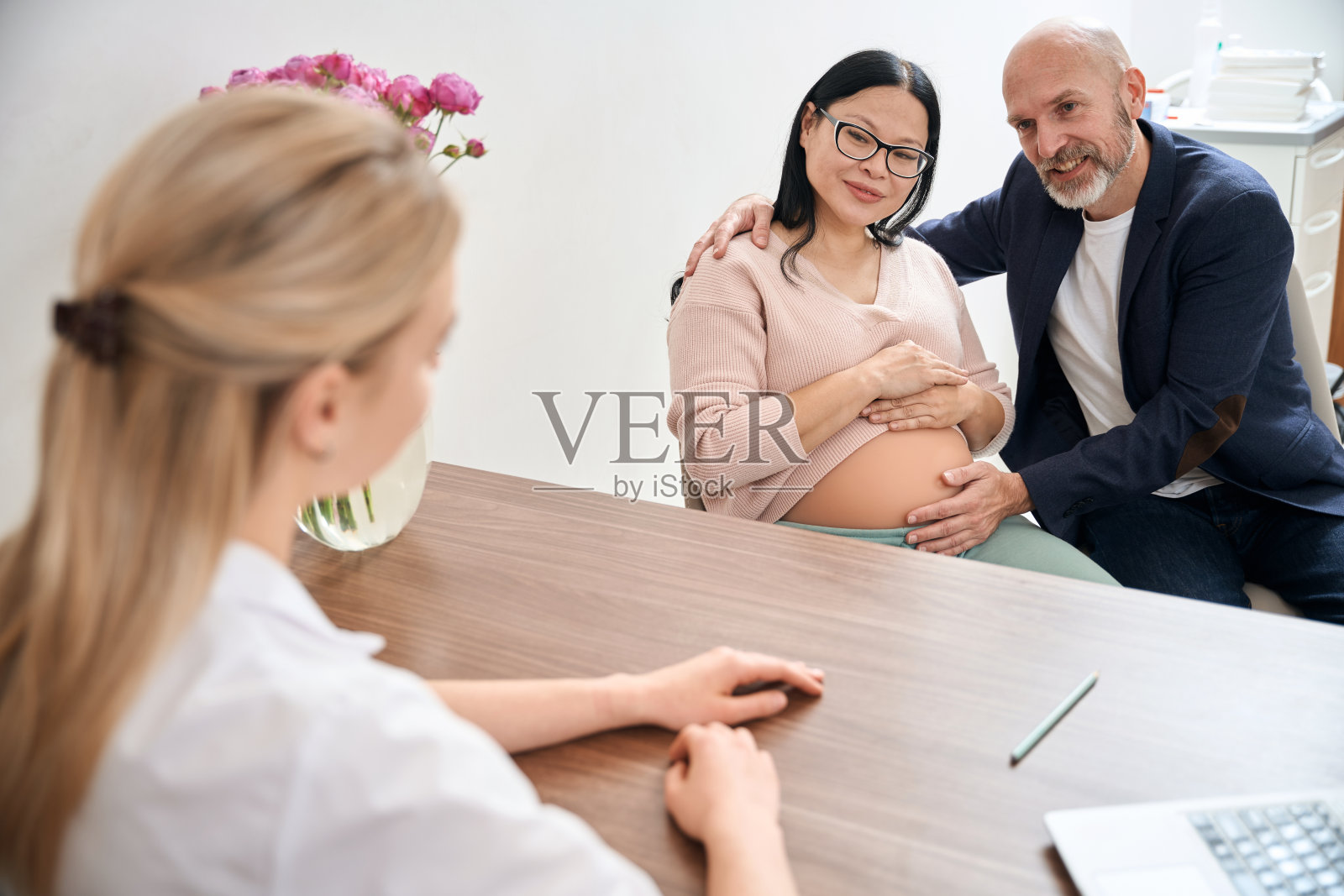 一对家庭夫妇拜访产科医生讨论妊娠晚期的问题照片摄影图片