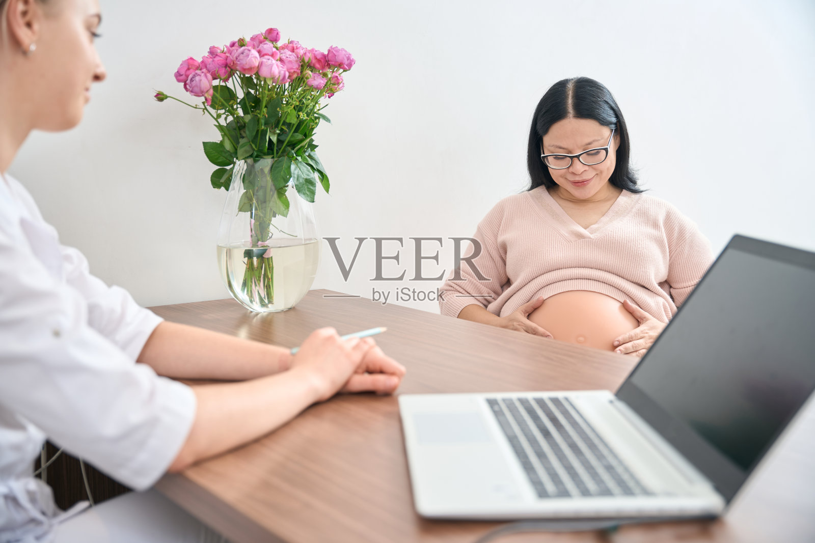 怀孕的亚洲妇女访问妇科医生办公室照片摄影图片