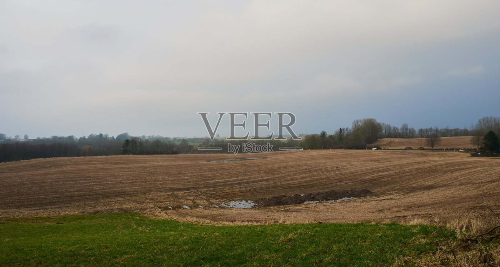 多云天空映衬下连绵起伏的田园风光照片摄影图片