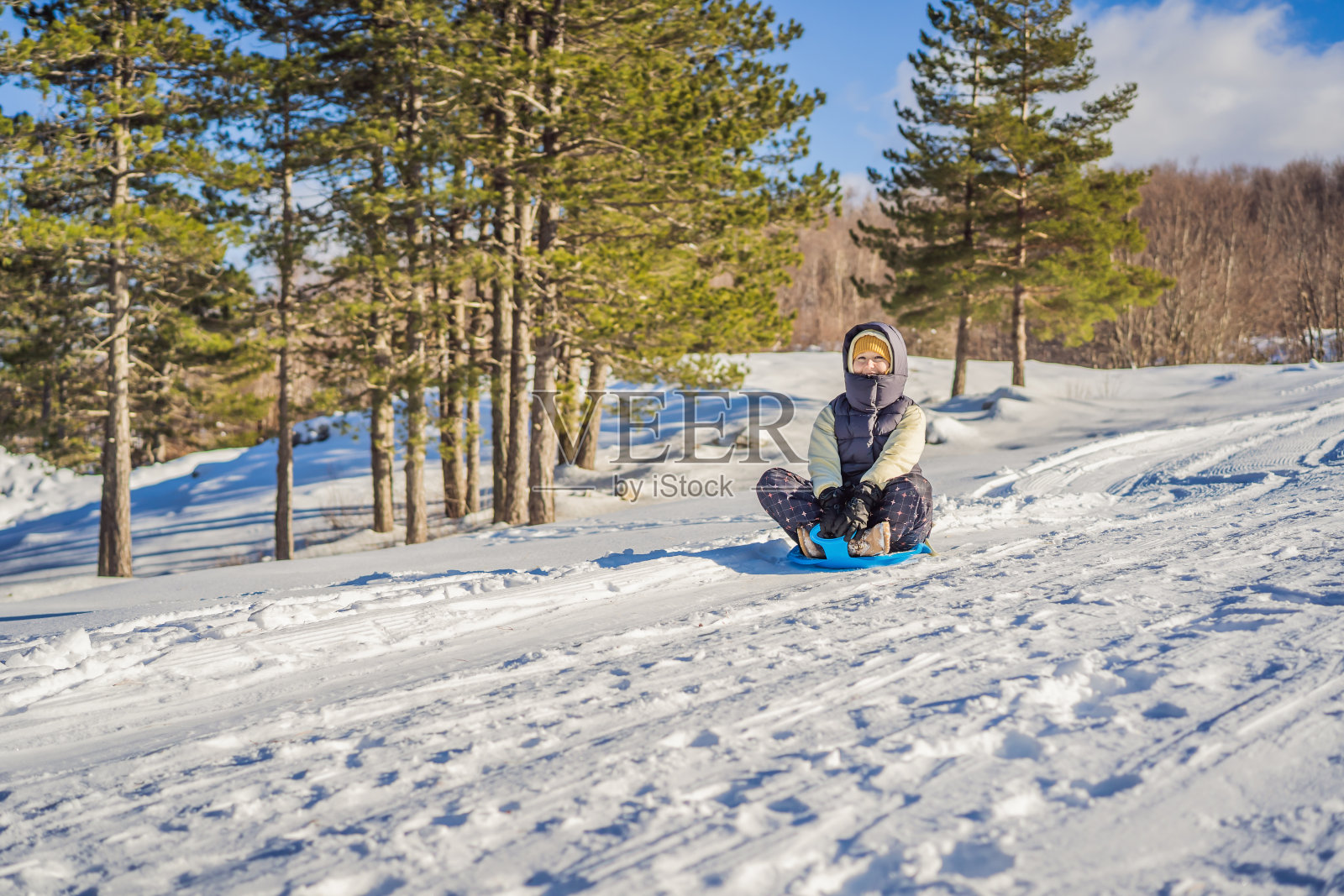 快乐的女人在滑下山坡时玩得很开心。有雪的冬季运动。人们骑着雪橇照片摄影图片
