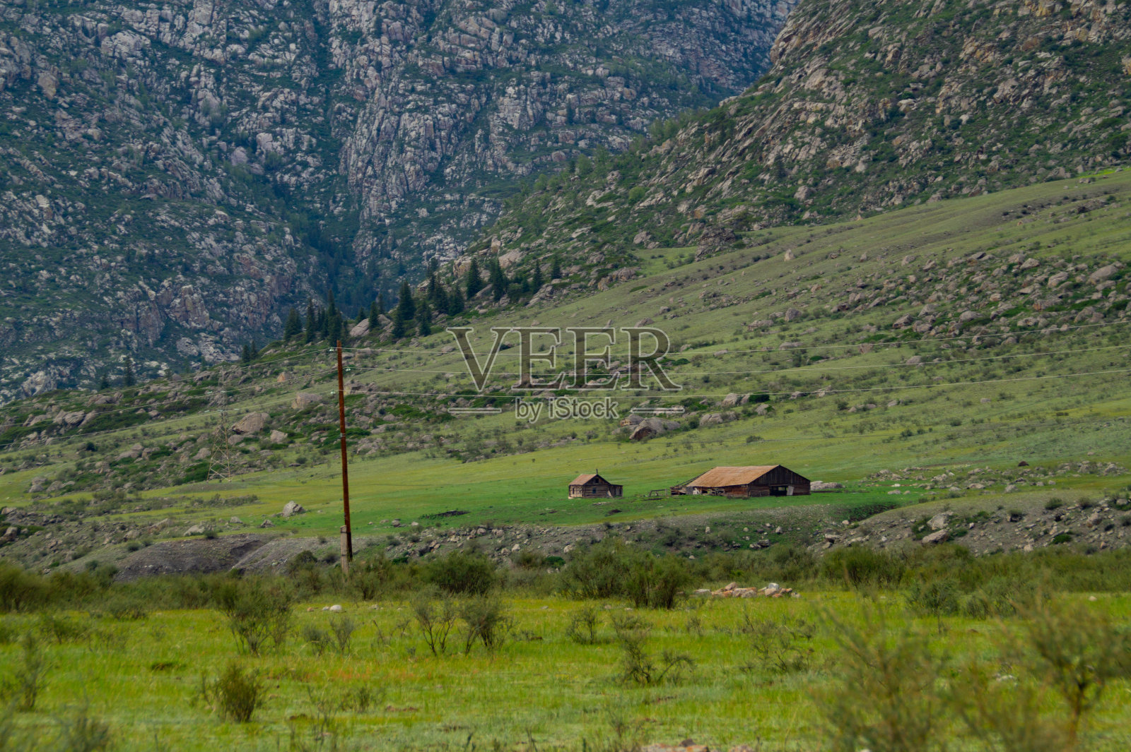 山脚下一座废弃的房子。照片摄影图片
