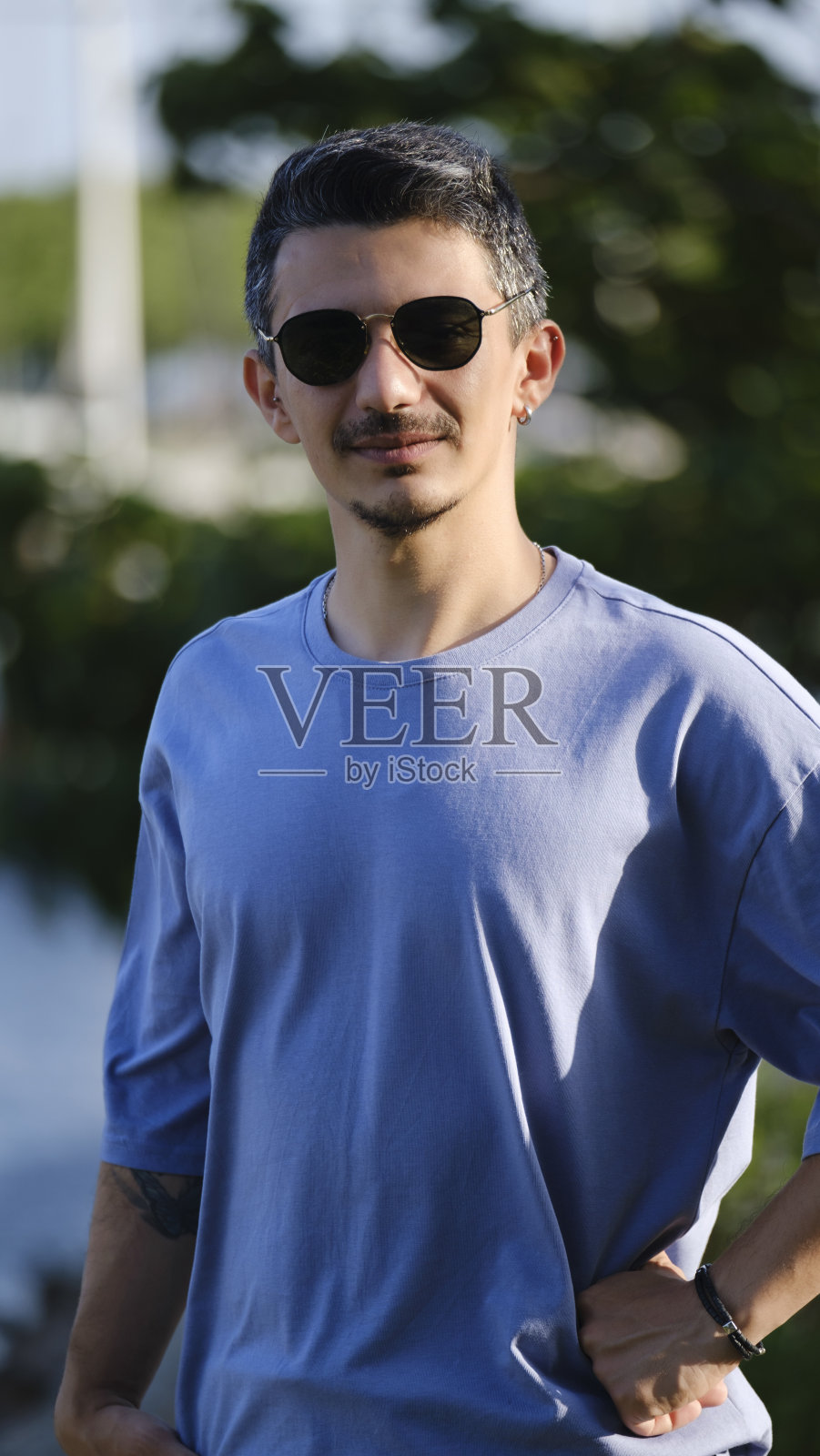 一个英俊、年轻、黑发的男人在海边消磨时光照片摄影图片