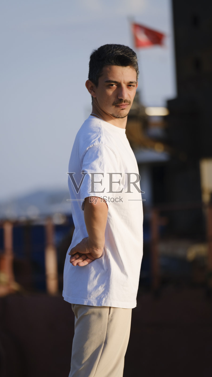 一个英俊、年轻、黑发的男人在海边消磨时光照片摄影图片