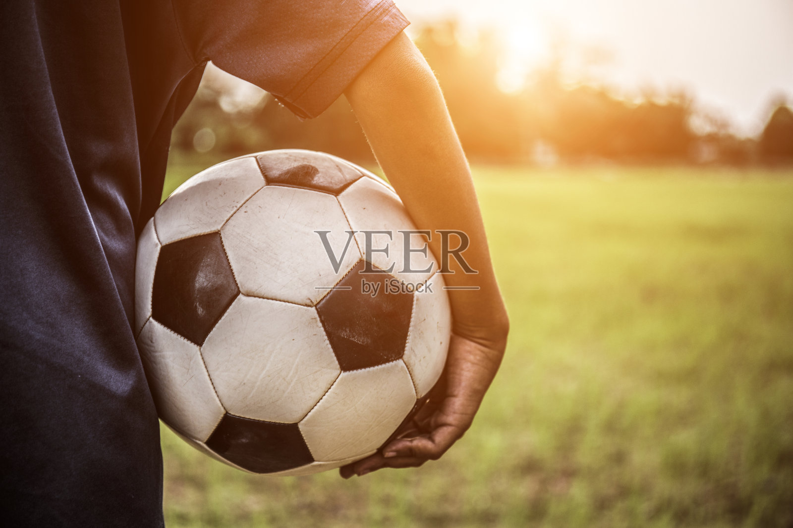 球员手持足球概念,男孩和足球梦想日落背景照片摄影图片