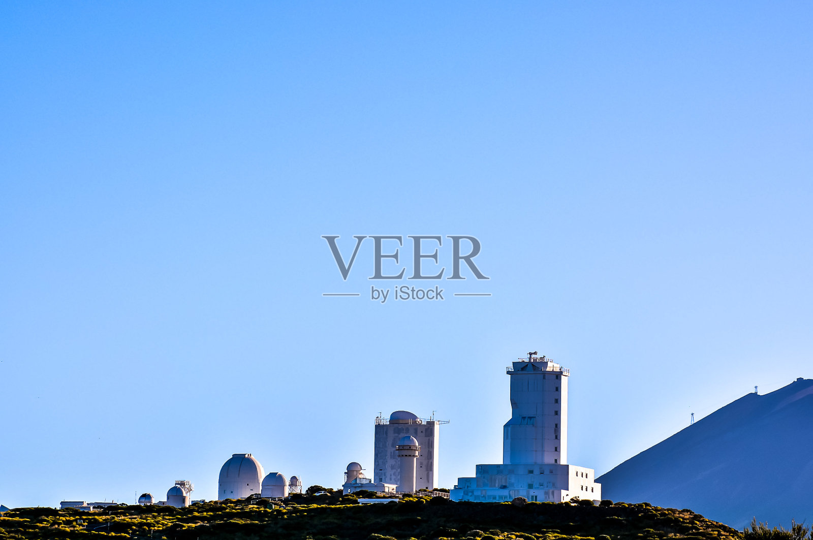 一座山脉,中间有一座巨大的白色建筑照片摄影图片