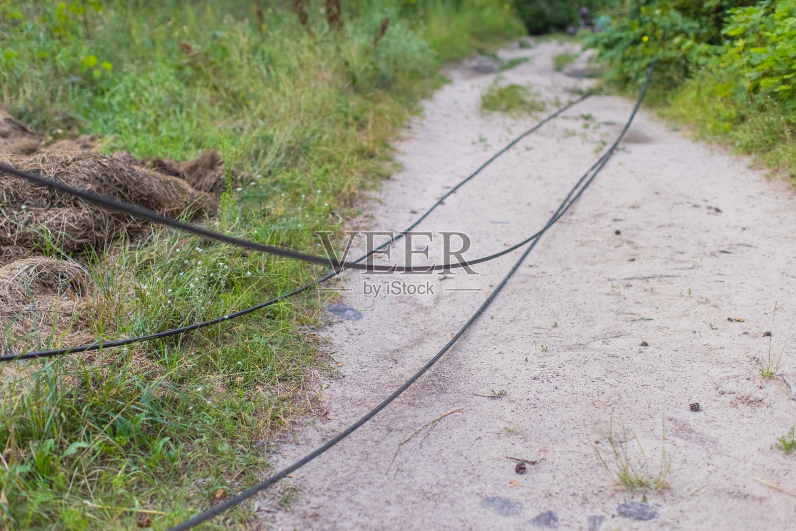 暴风雨过后,电线杆断了。电线断了。照片摄影图片
